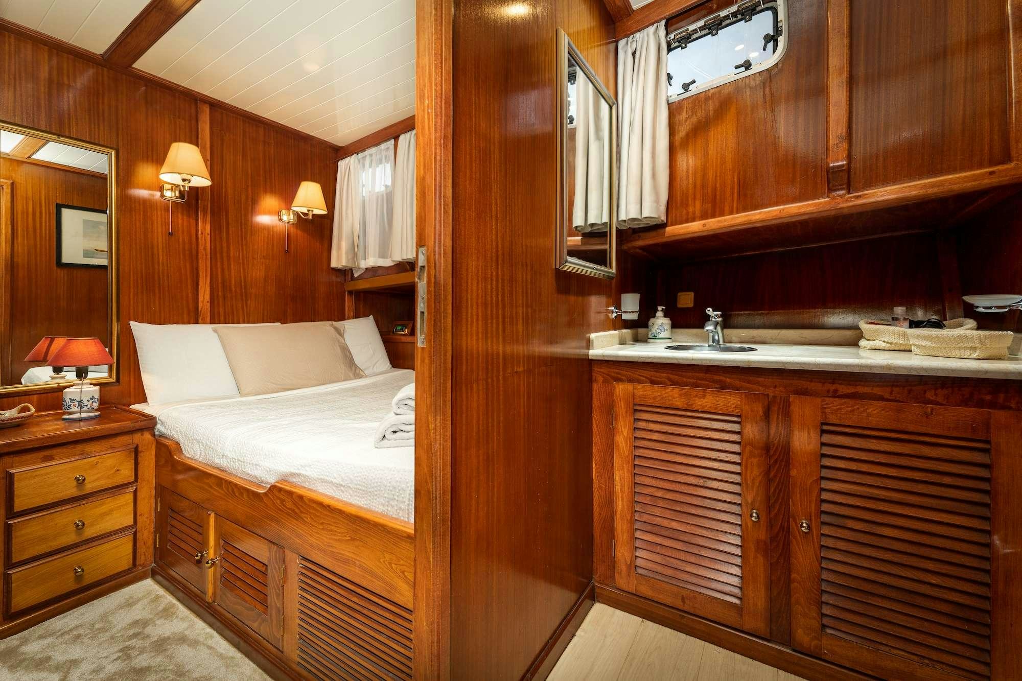 a bedroom with a bed and a sink aboard MYRA Yacht for Charter