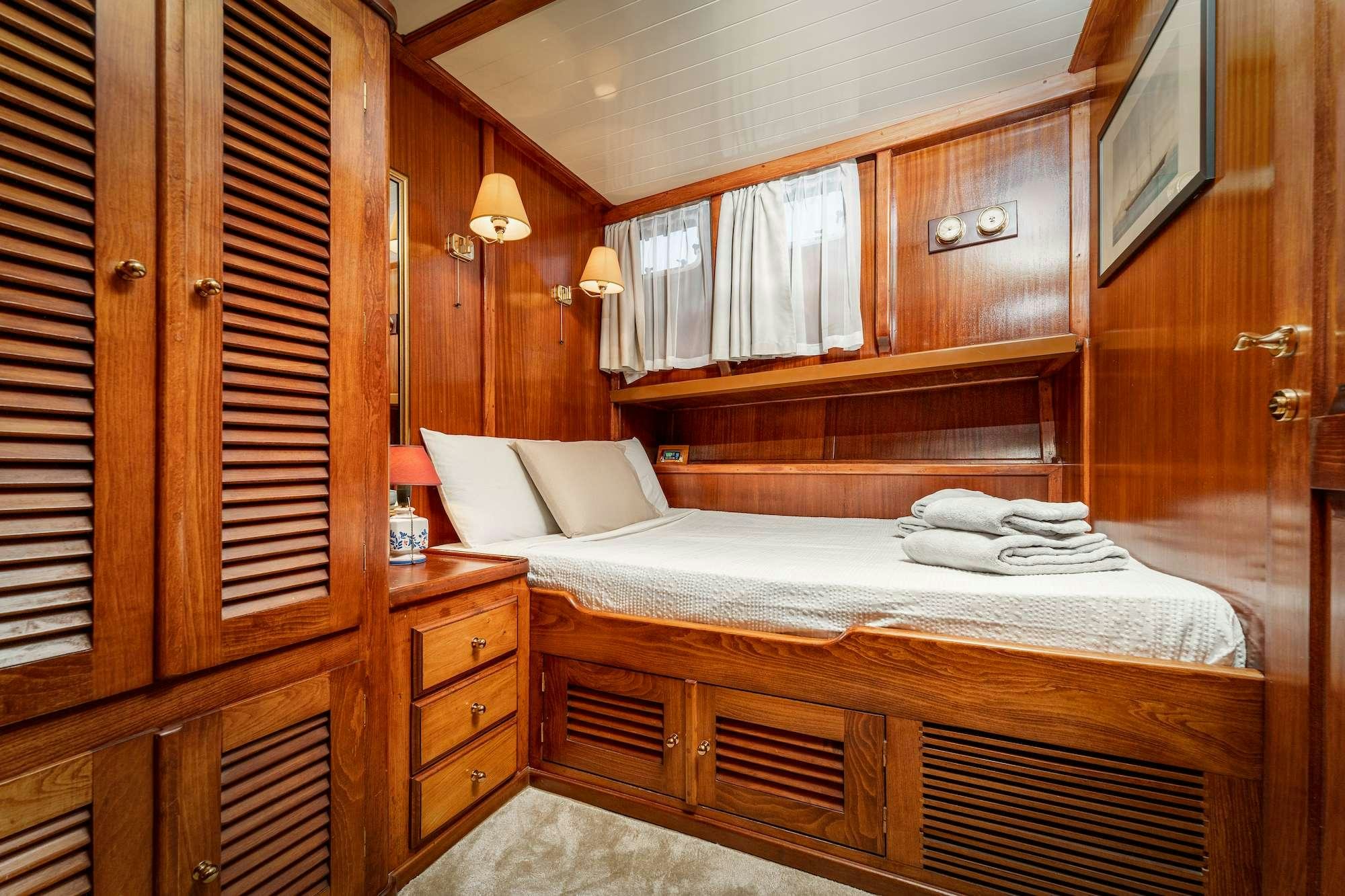 a room with a bed and a window aboard MYRA Yacht for Charter