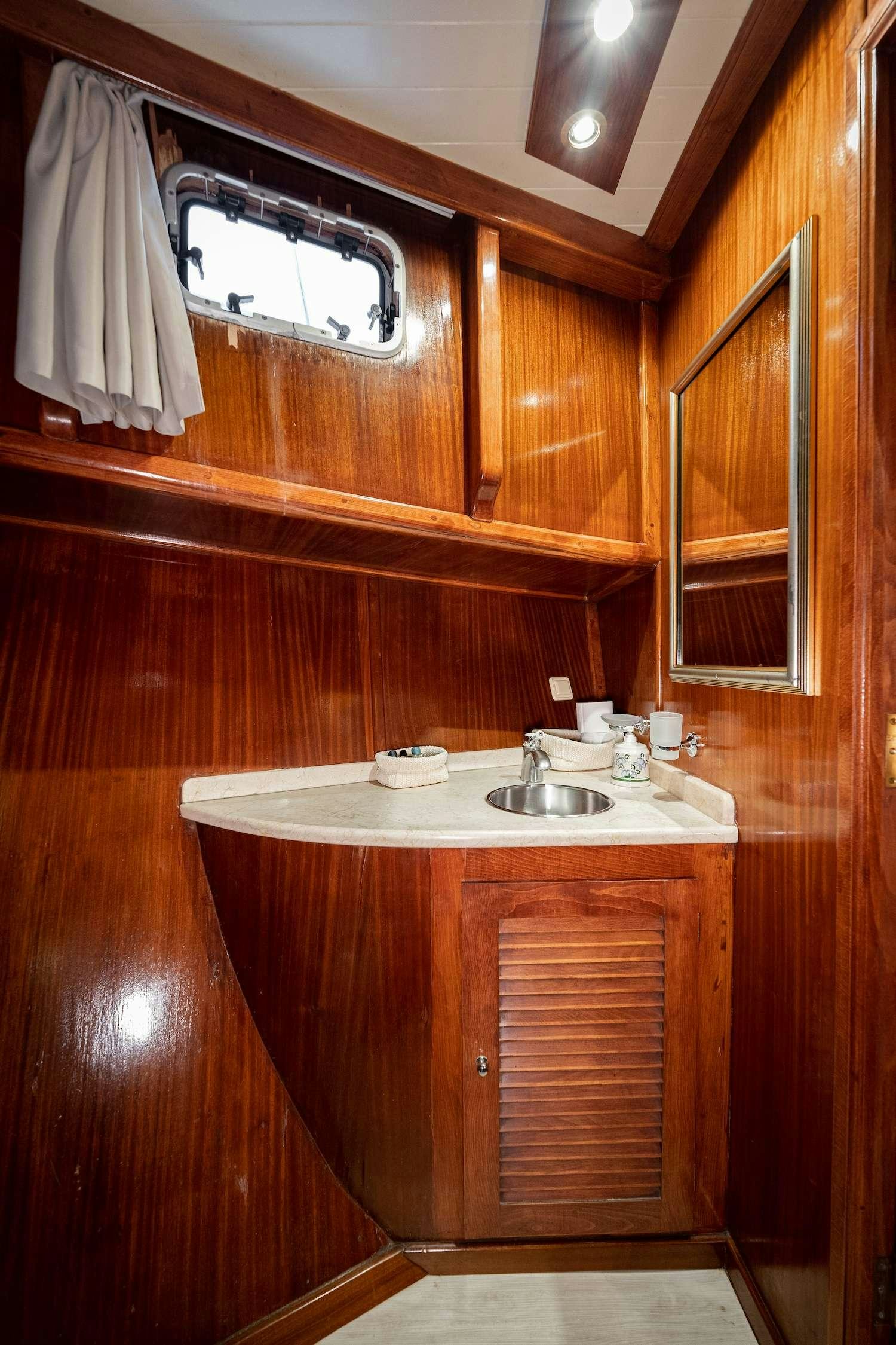 a bathroom with wooden cabinets aboard MYRA Yacht for Charter