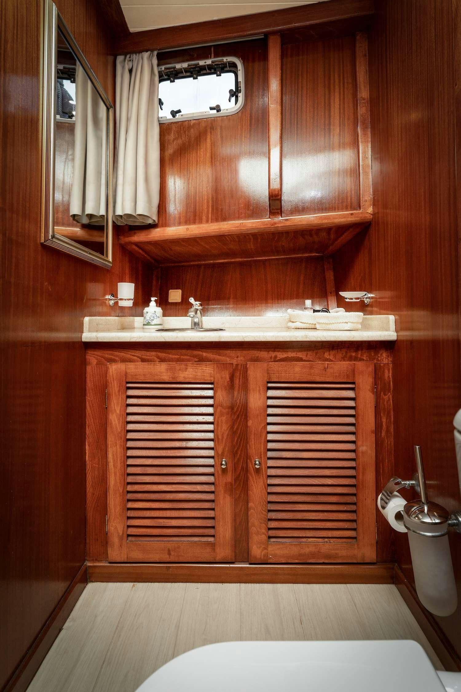 a bathroom with wooden cabinets aboard MYRA Yacht for Charter