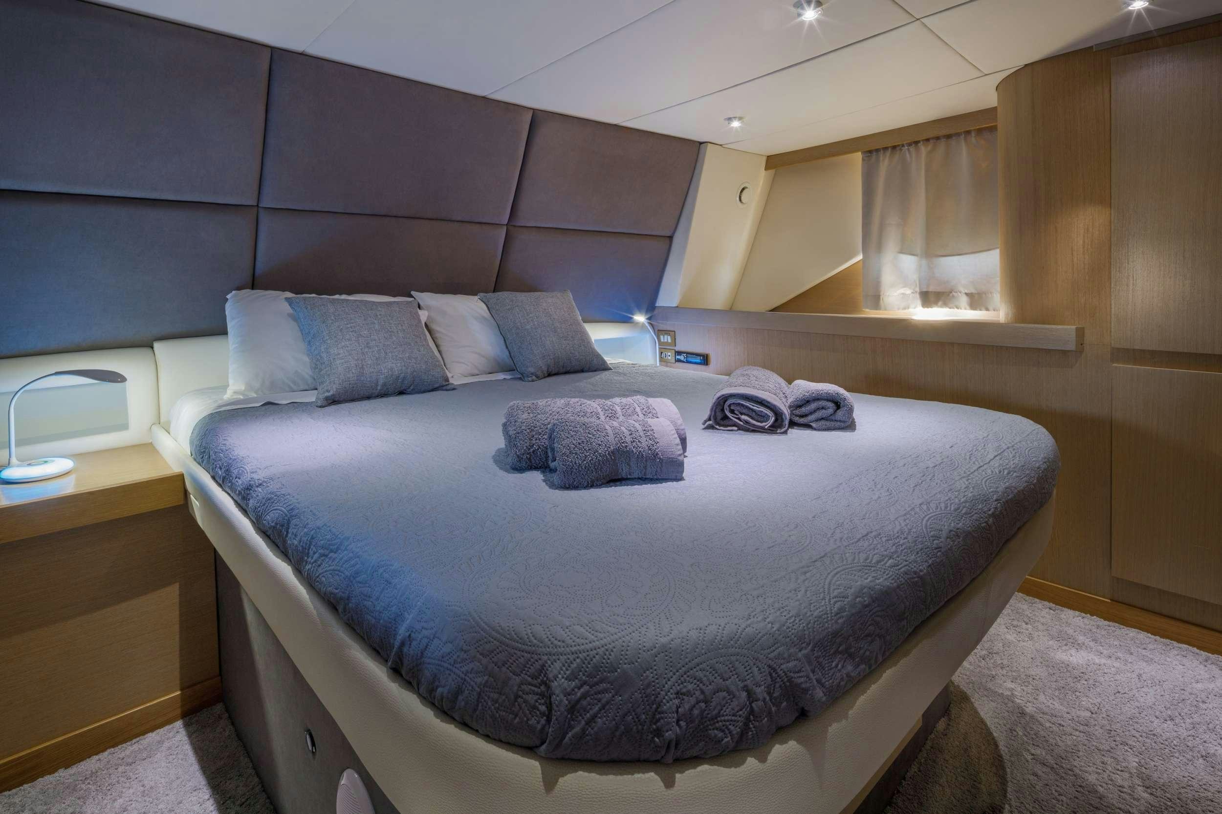 a bed with a blue comforter aboard Marios L Yacht for Charter