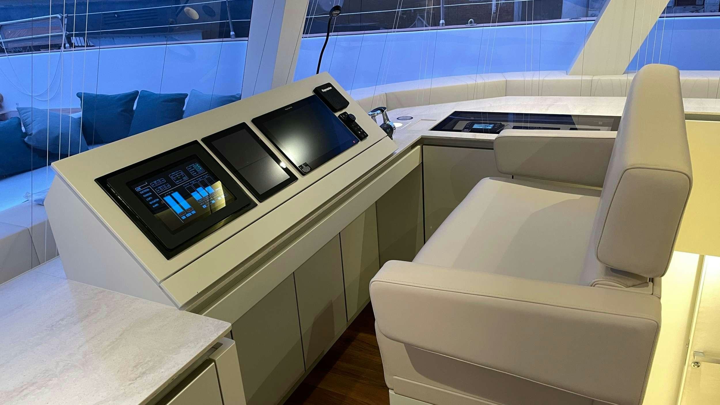 a room with a couch and a table with a laptop on it aboard SEACLUSION Yacht for Charter