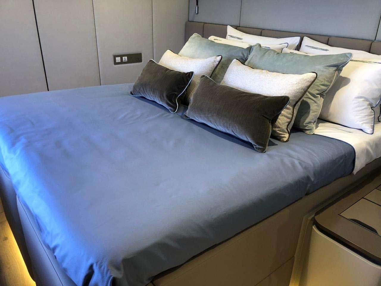 a bed with blue sheets aboard SEACLUSION Yacht for Charter