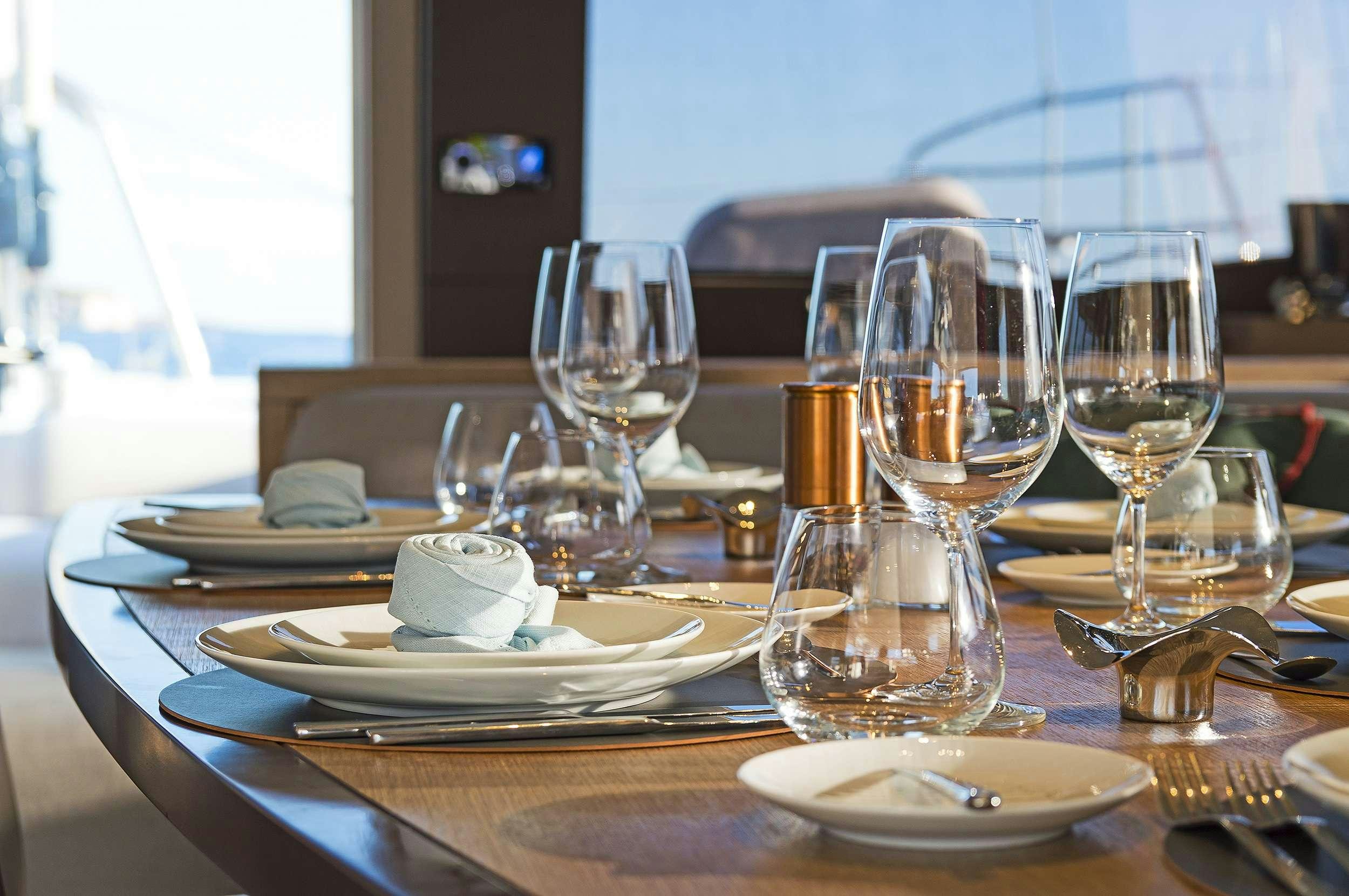 a table with plates and glasses aboard DAIQUIRI Yacht for Charter