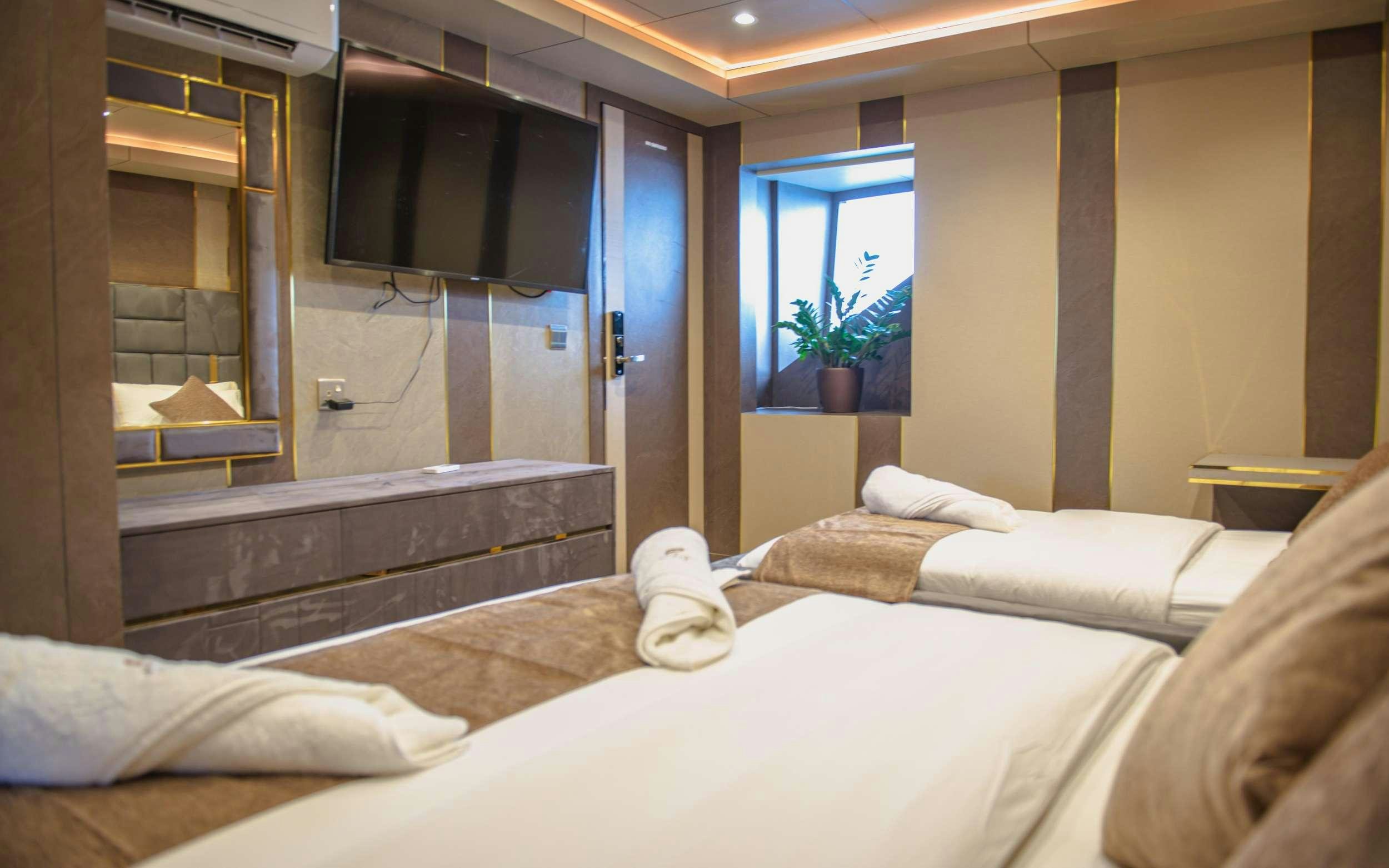 a room with a bed and a television aboard ARK NOBLE Yacht for Charter