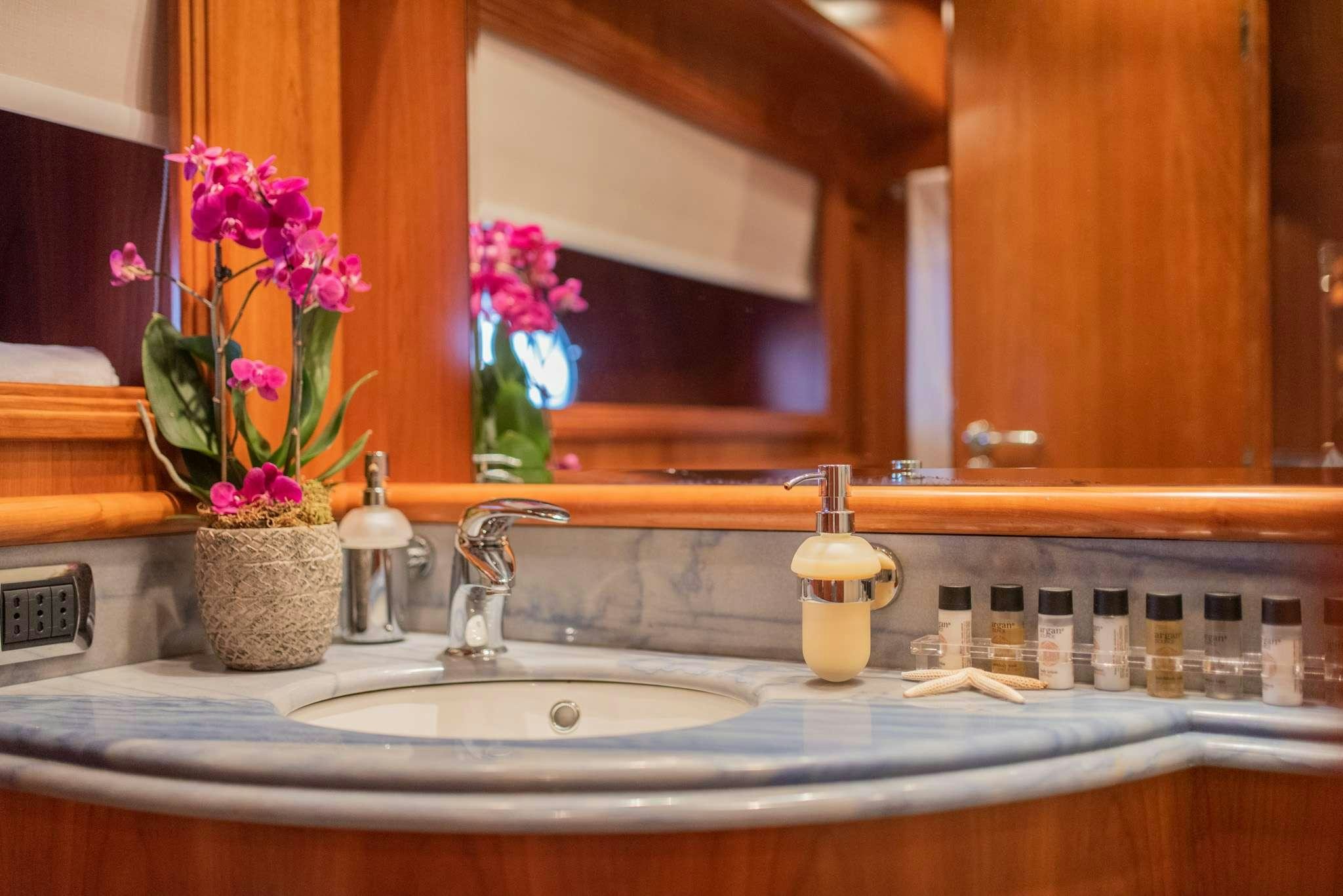 a bathroom sink with a flower vase aboard SALTY Yacht for Charter