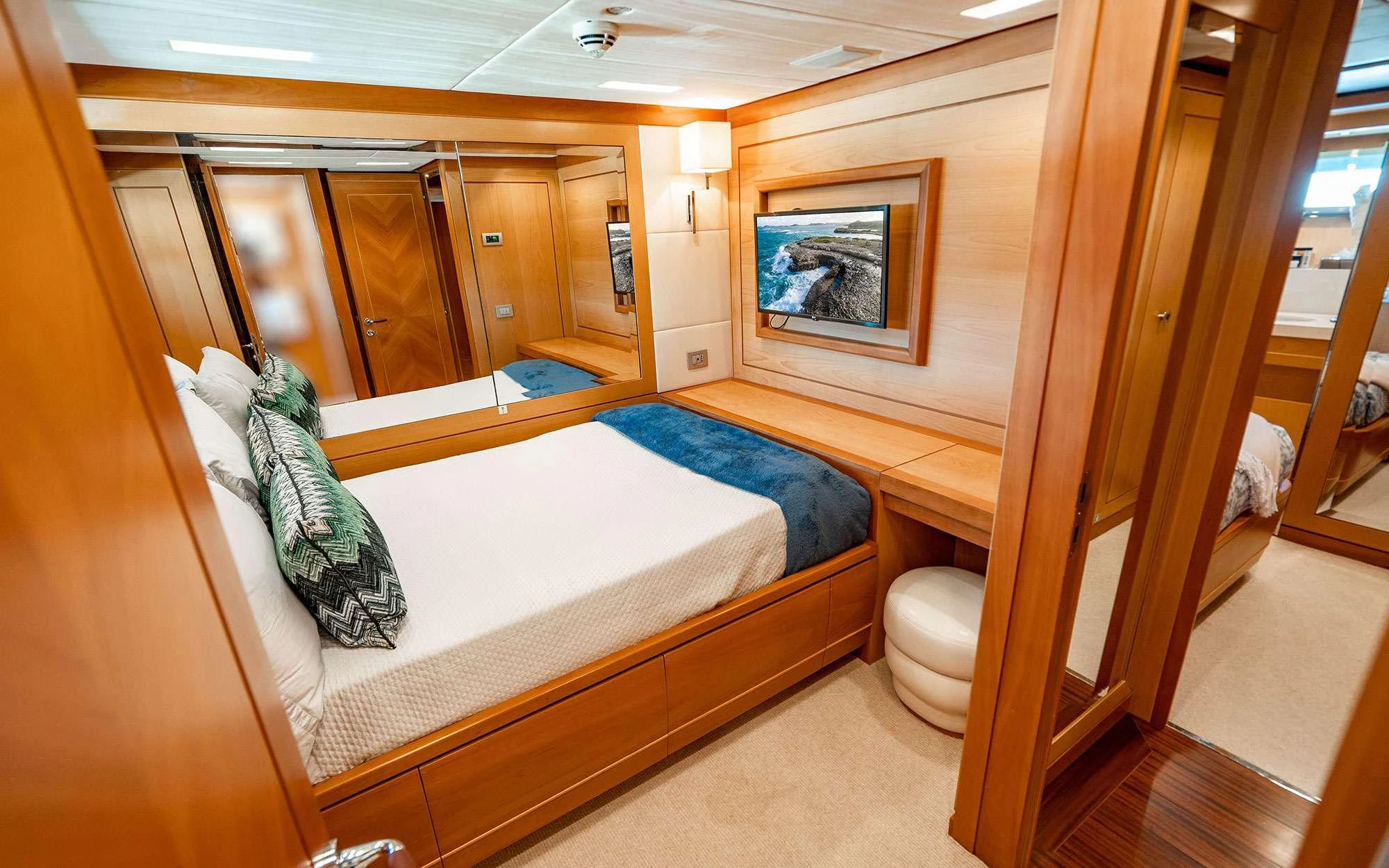 a bedroom with a large mirror aboard WHY NOT Yacht for Charter
