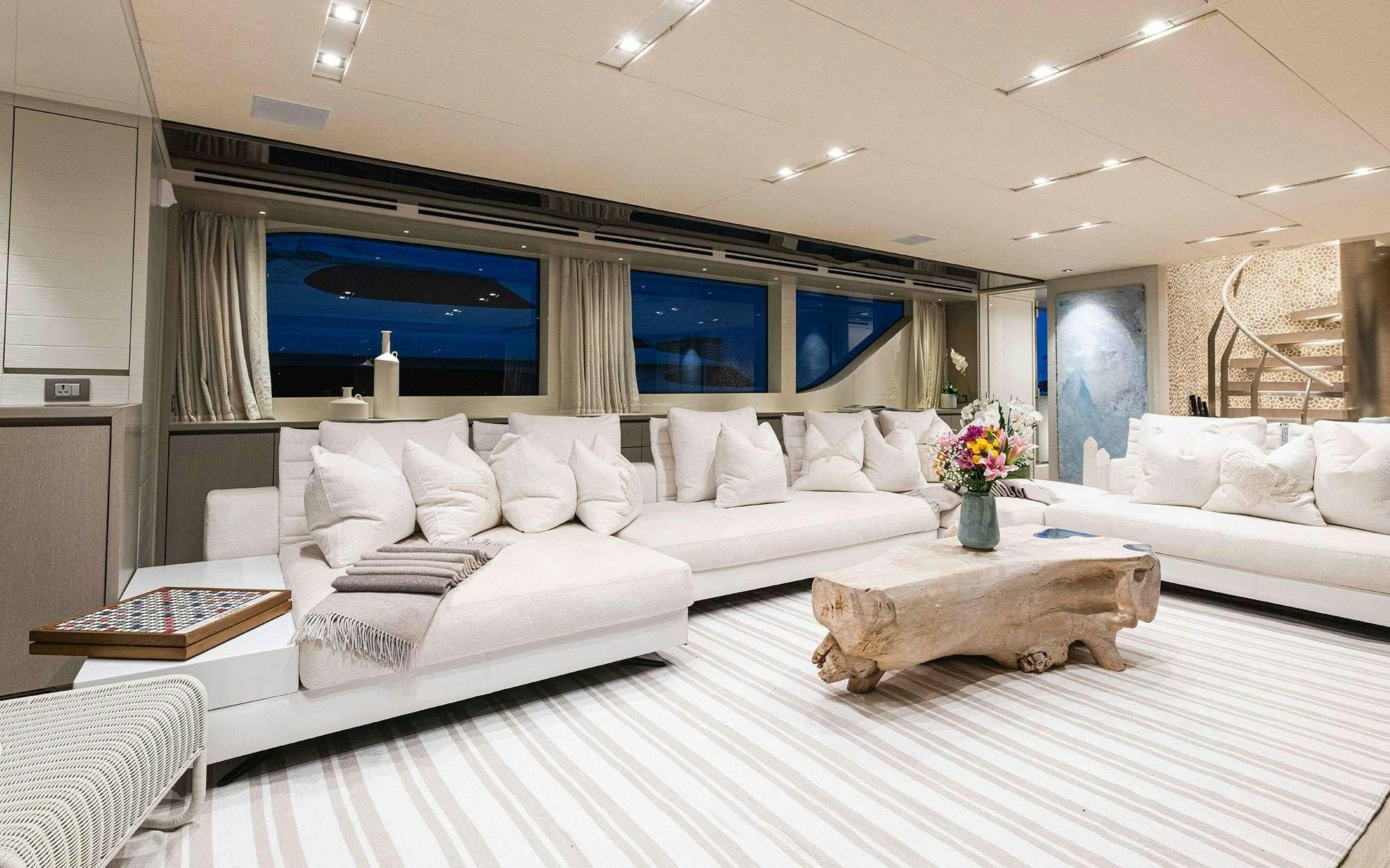 a large white living room with a large white bed and a large screen aboard HALCYON Yacht for Charter