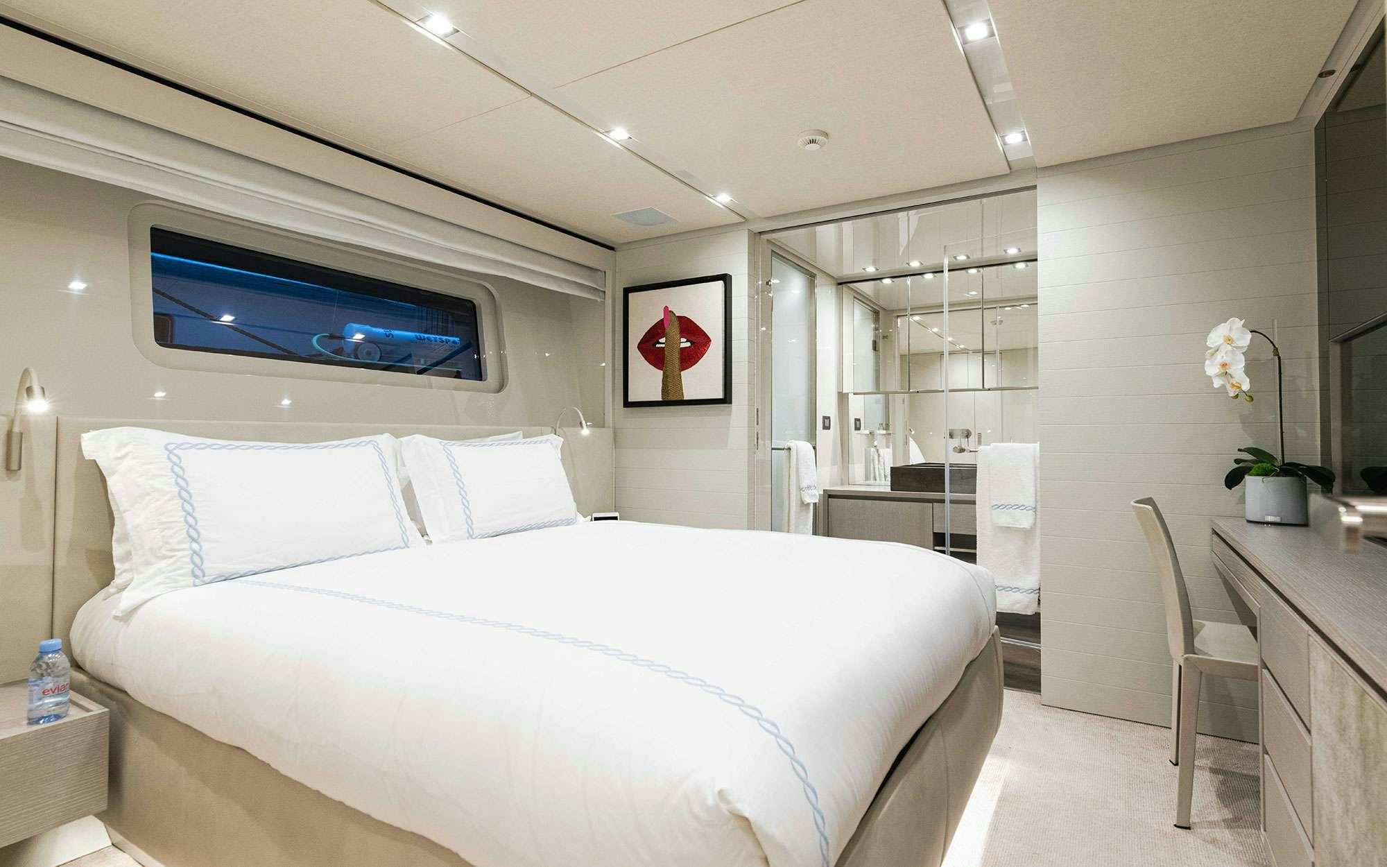 a bedroom with a bed and a tv on the wall aboard HALCYON Yacht for Charter