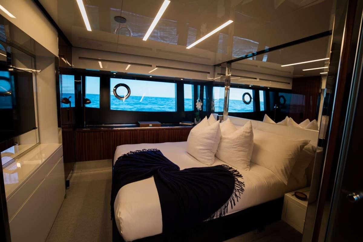 a room with a bed and a tv on the wall aboard NOT YET Yacht for Charter