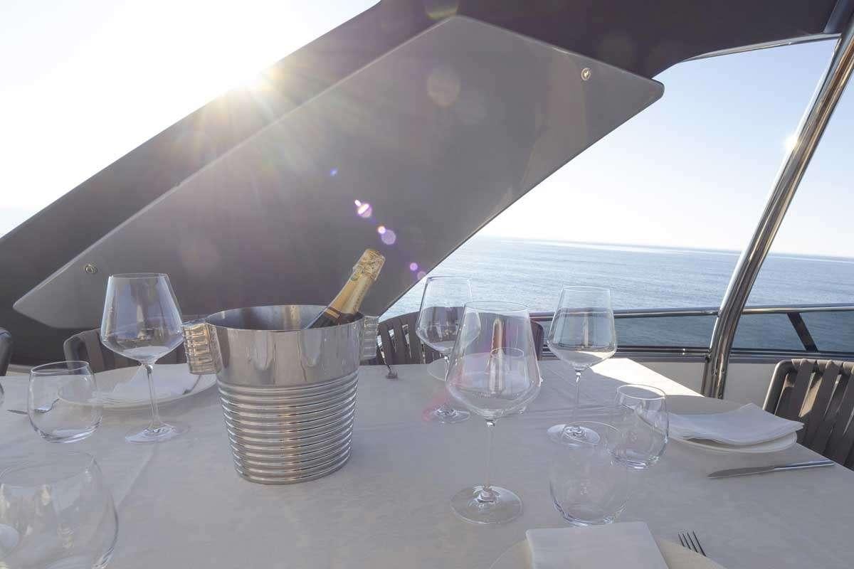 a table with a bucket and wine glasses on it aboard EM3 Yacht for Charter