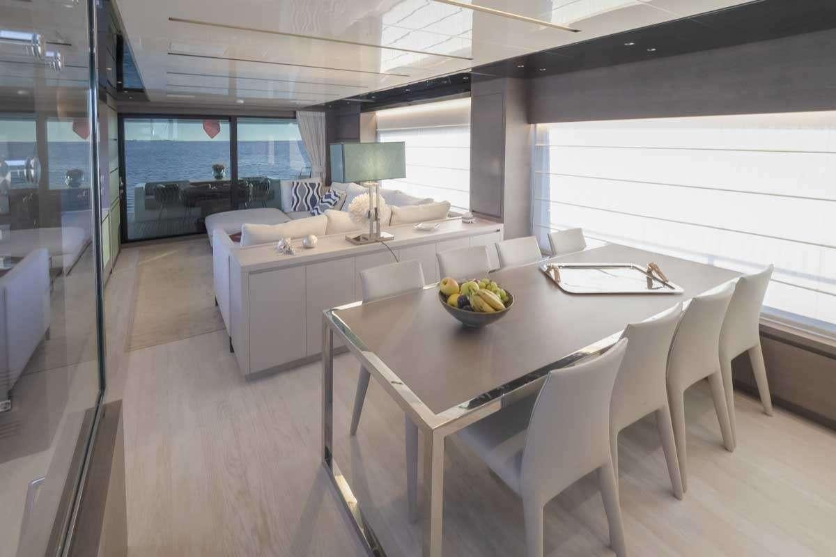 a large kitchen with white chairs aboard EM3 Yacht for Charter