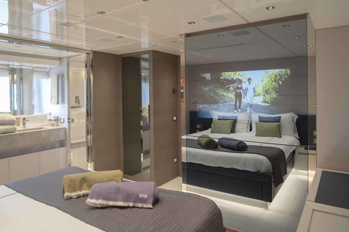 a room with a bed and a large window aboard EM3 Yacht for Charter