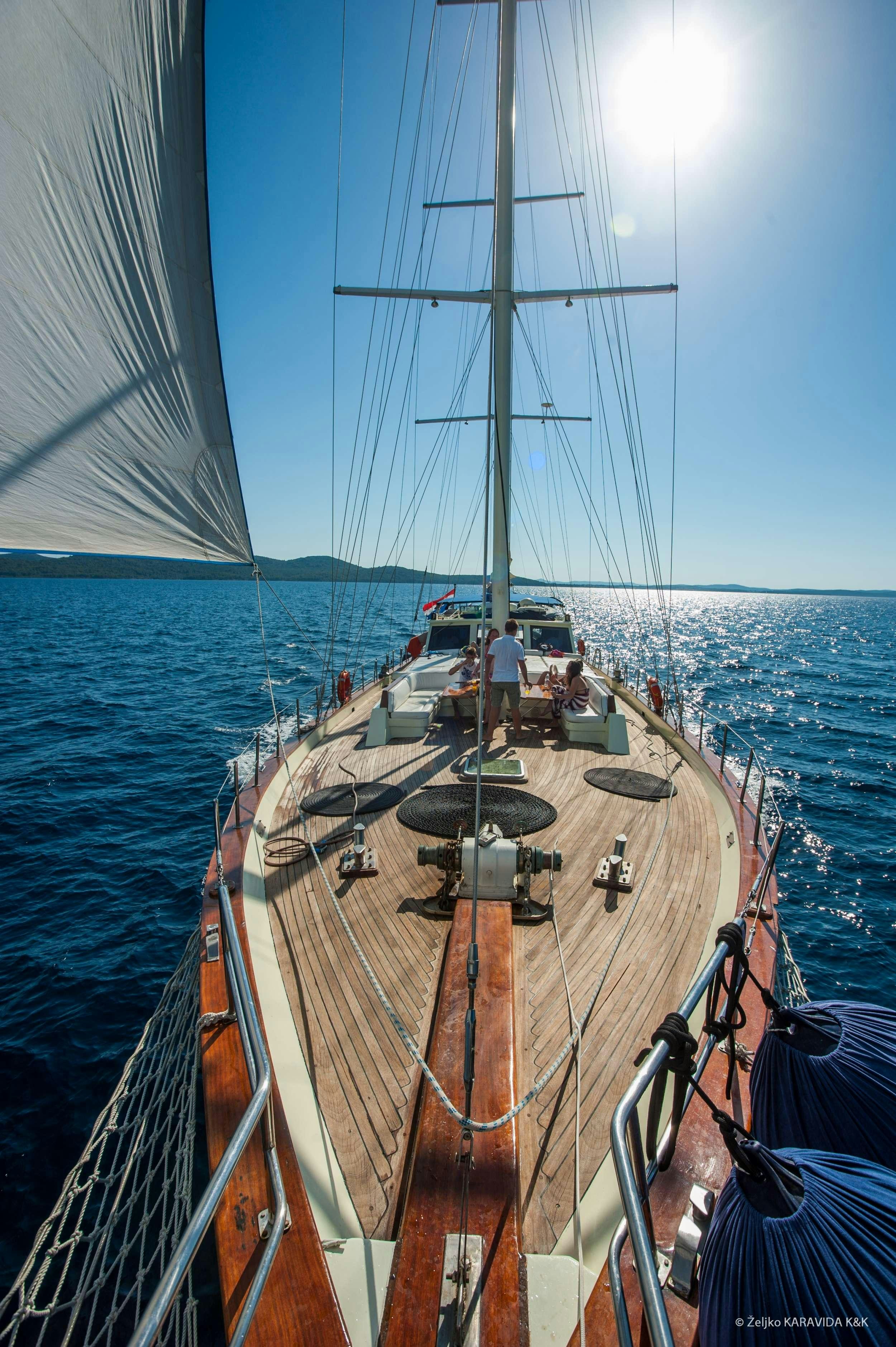 a boat with a sail on the water aboard FORTUNA Yacht for Charter