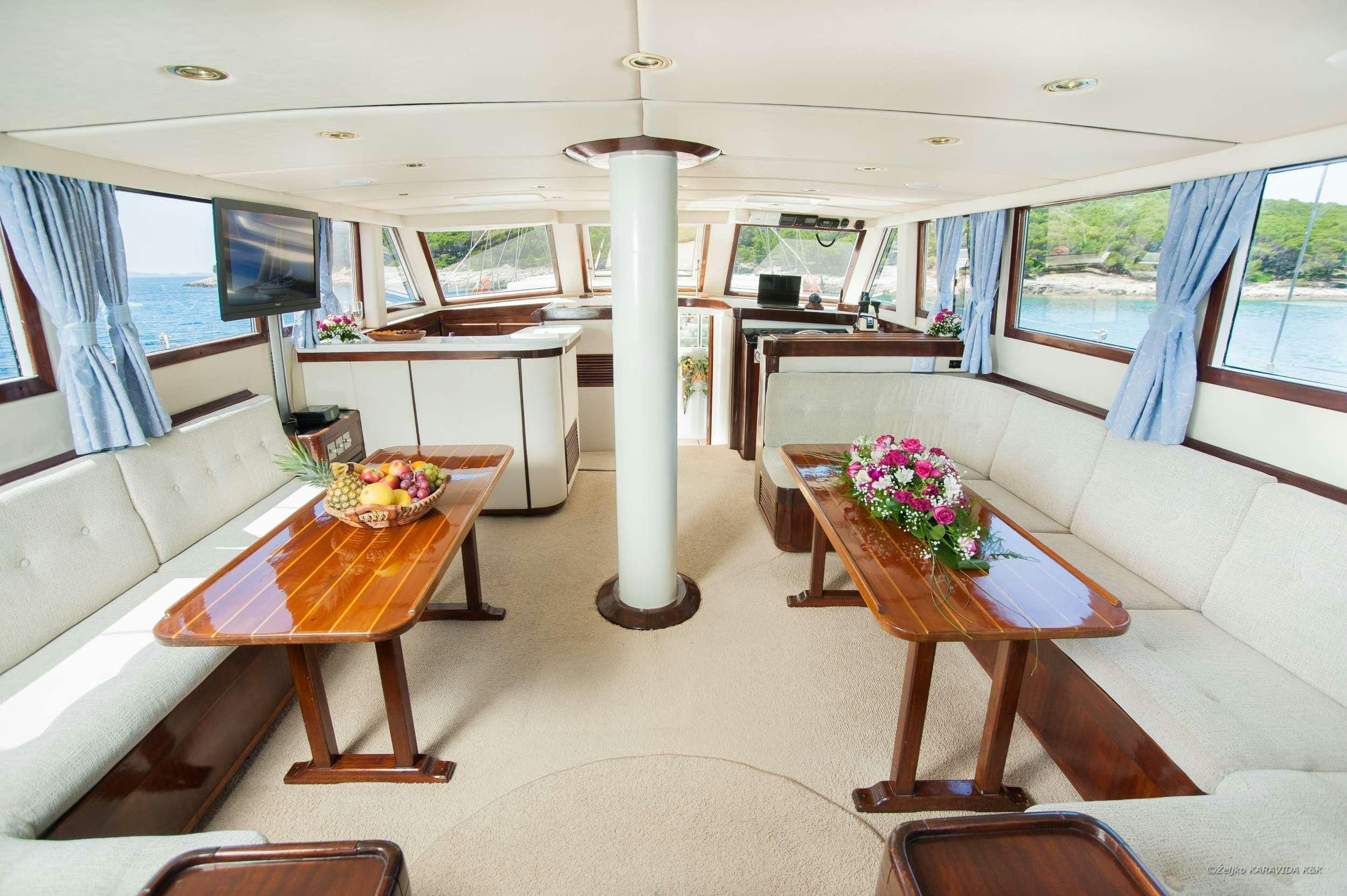 a living room with a table and chairs aboard FORTUNA Yacht for Charter