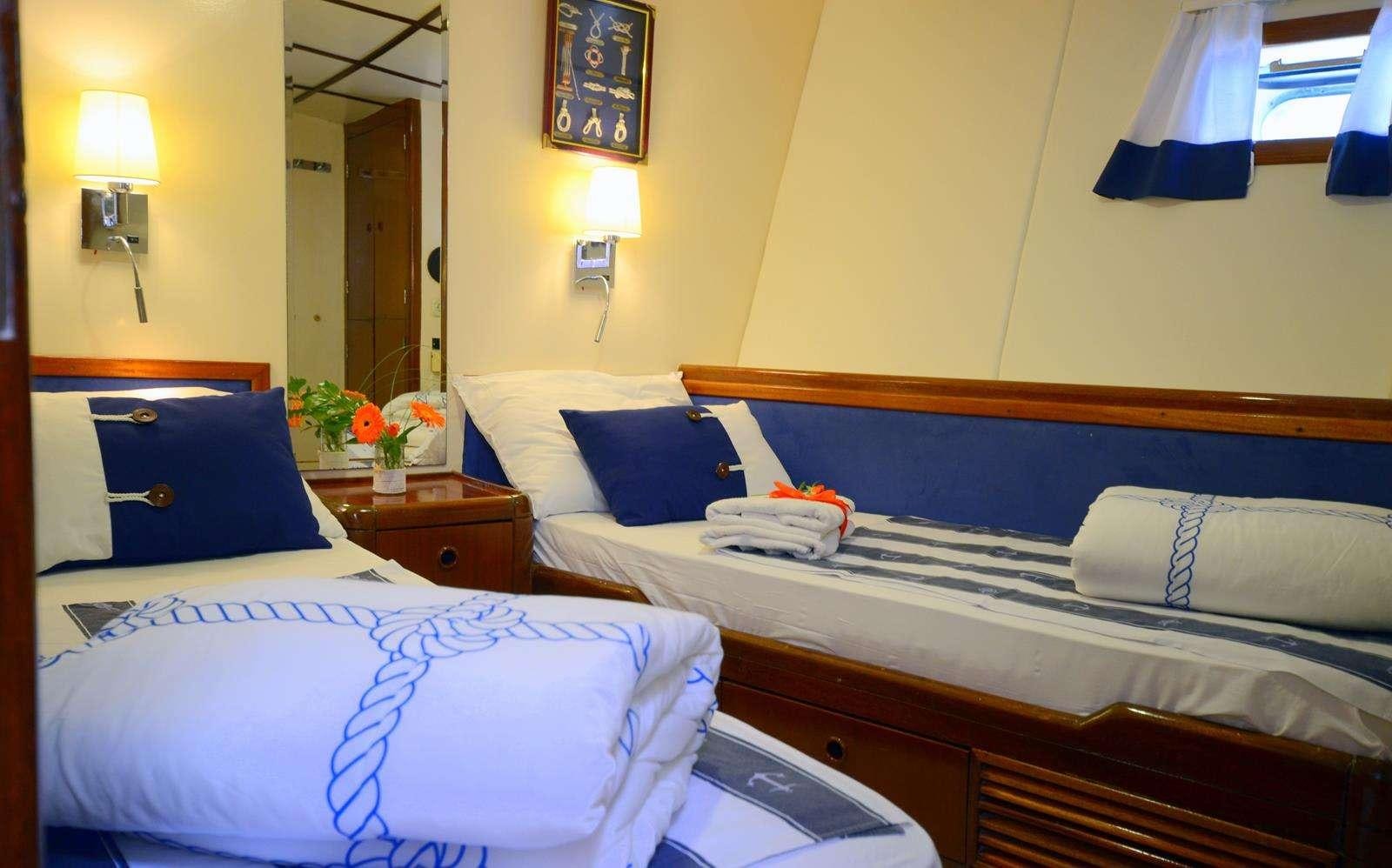 a couple of beds in a hotel room aboard FORTUNA Yacht for Charter