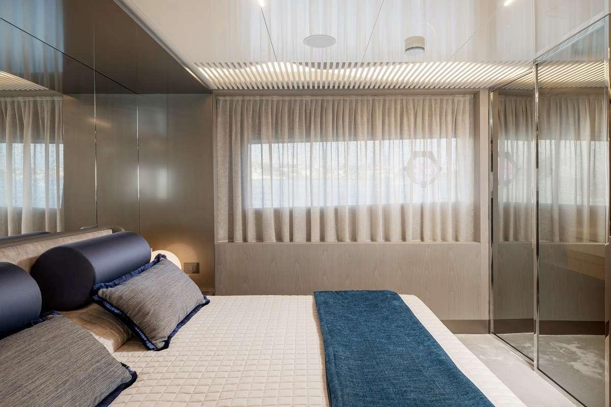 a bed with a blue pillow aboard YEMAJA Yacht for Charter