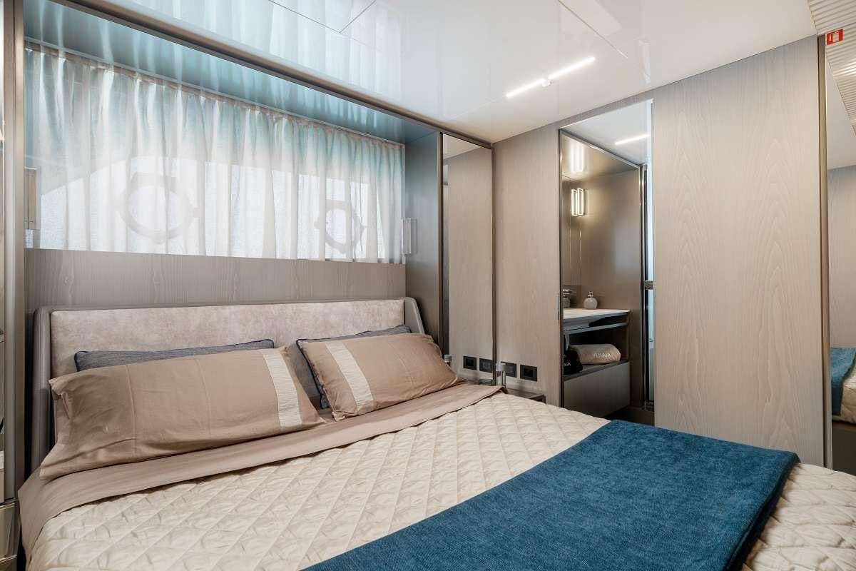 a bed with a blue sheet aboard YEMAJA Yacht for Charter