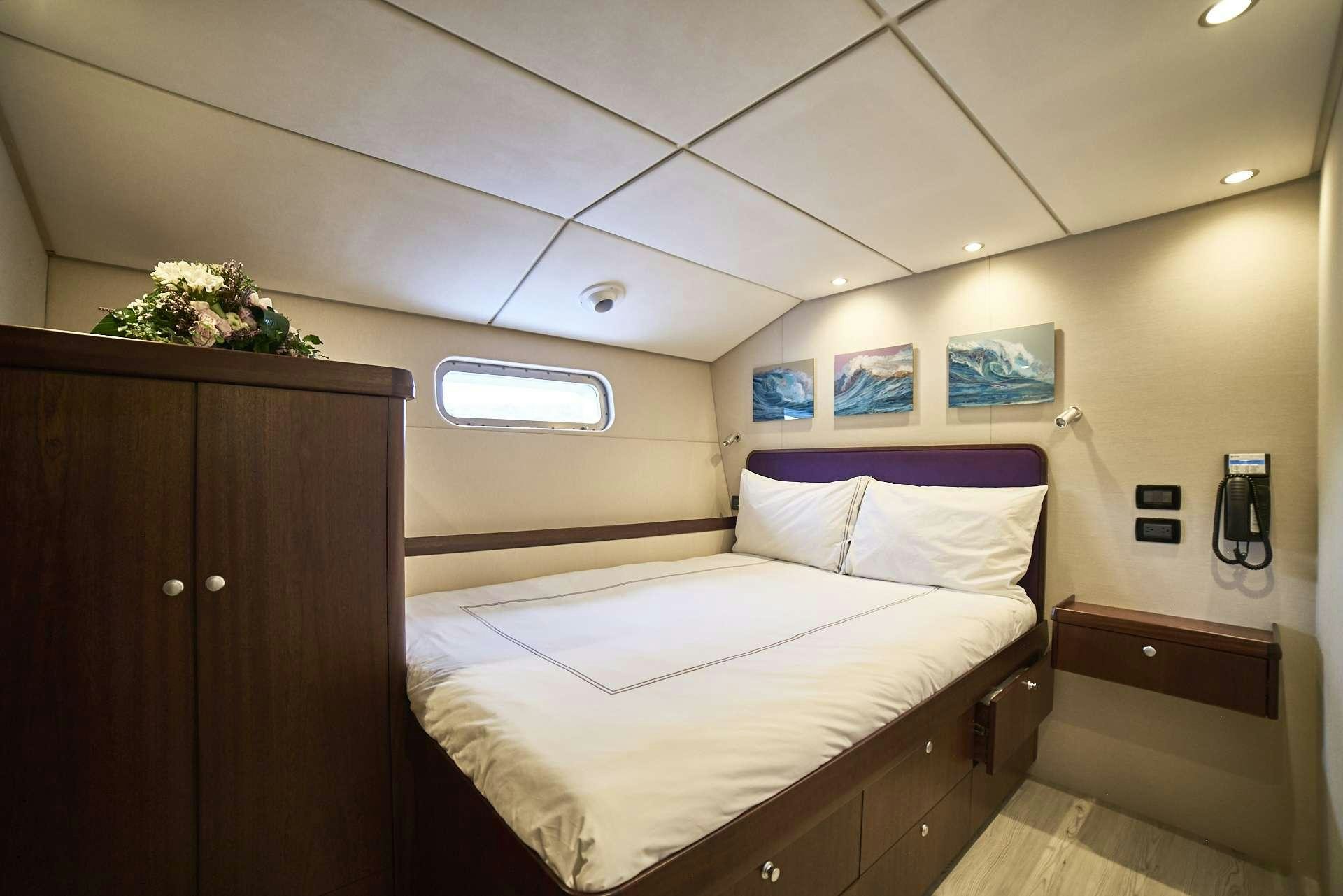a bedroom with a bed and a plant on the wall aboard ICEBERG Yacht for Charter