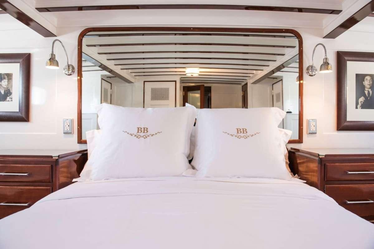 a bed with white sheets aboard TIMELESS Yacht for Charter