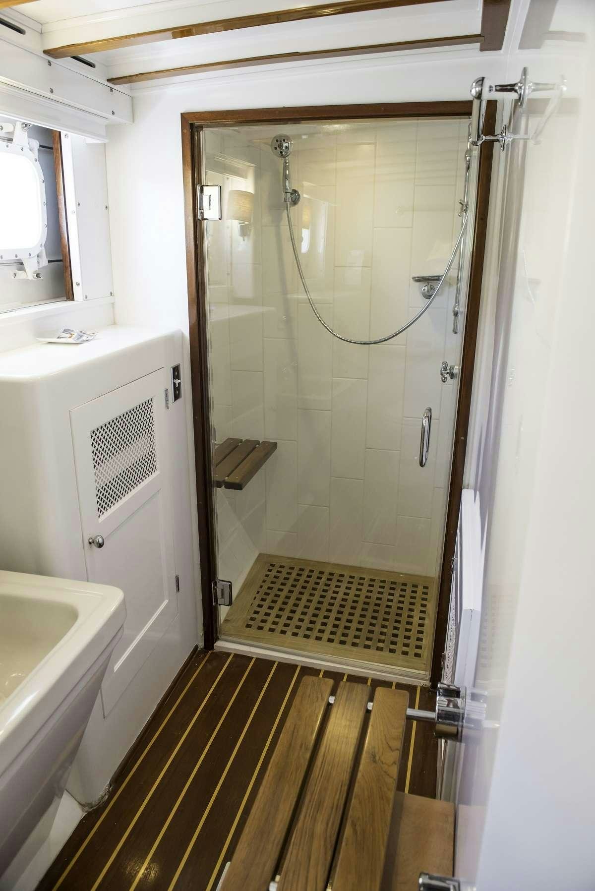 a bathroom with a shower unit and sink aboard TIMELESS Yacht for Charter