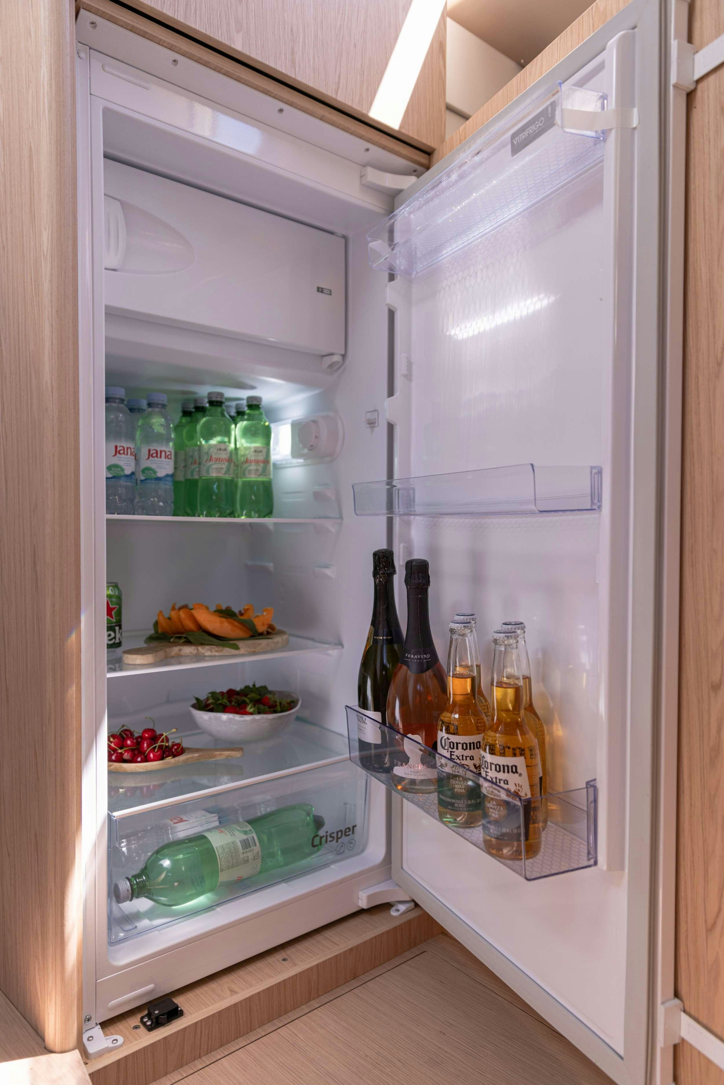 a refrigerator with bottles and food aboard WHITE BIRD Yacht for Charter