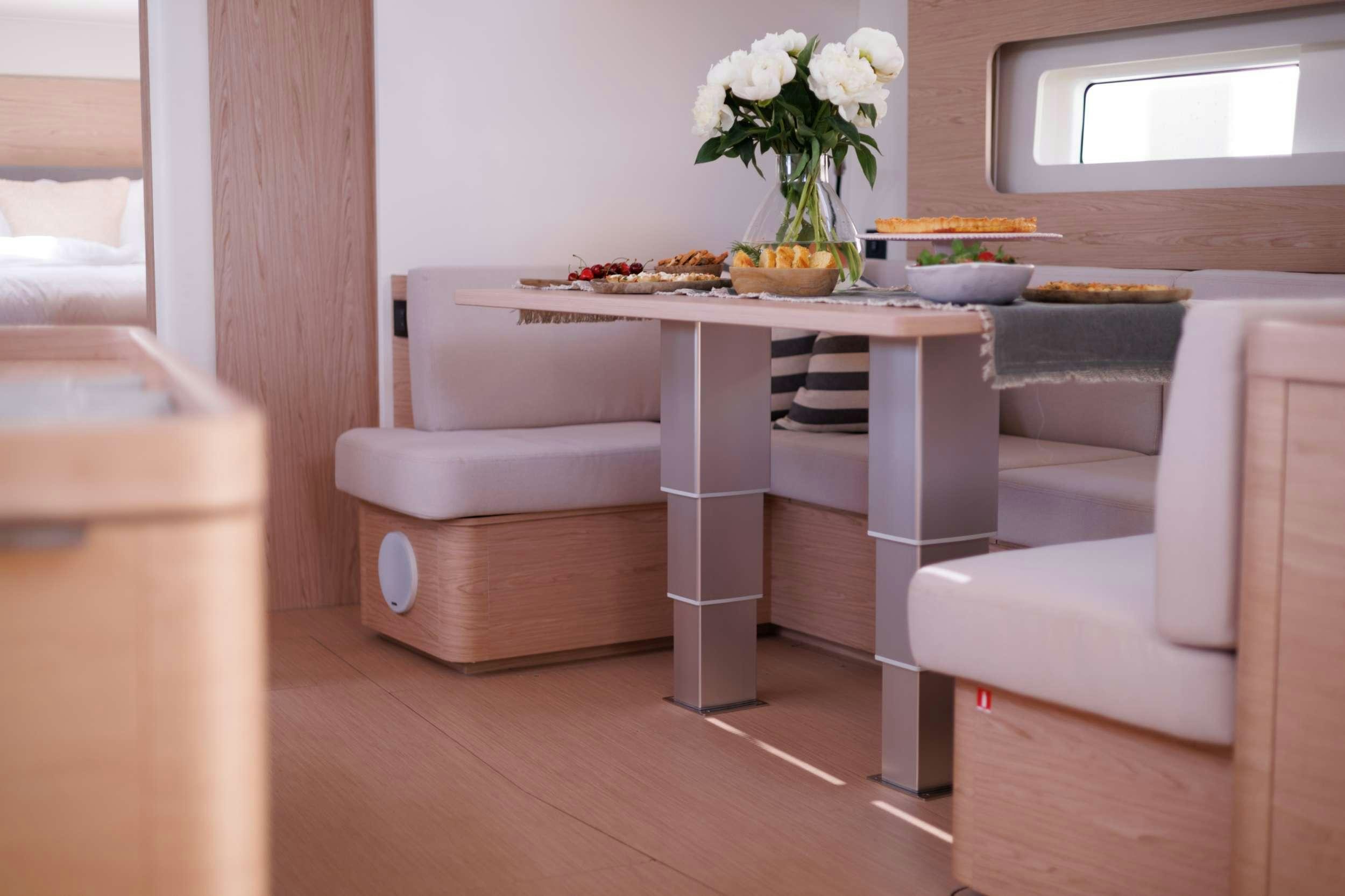 a white table with a vase of flowers on it aboard WHITE BIRD Yacht for Charter