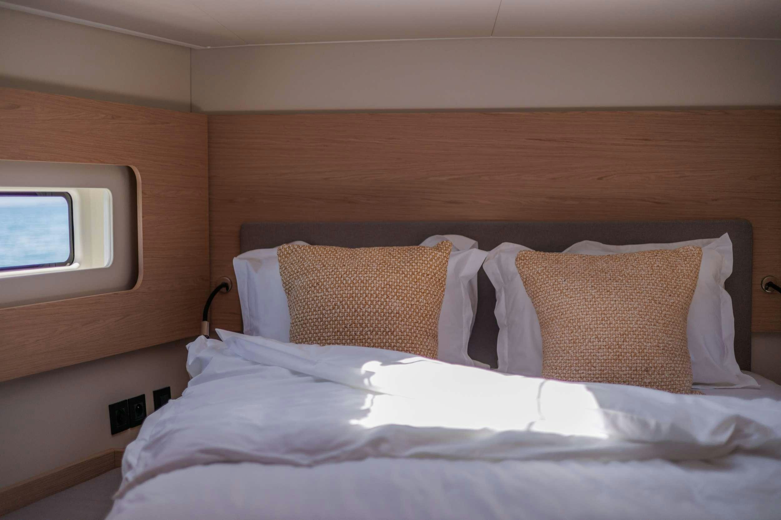 a bed with pillows aboard WHITE BIRD Yacht for Charter