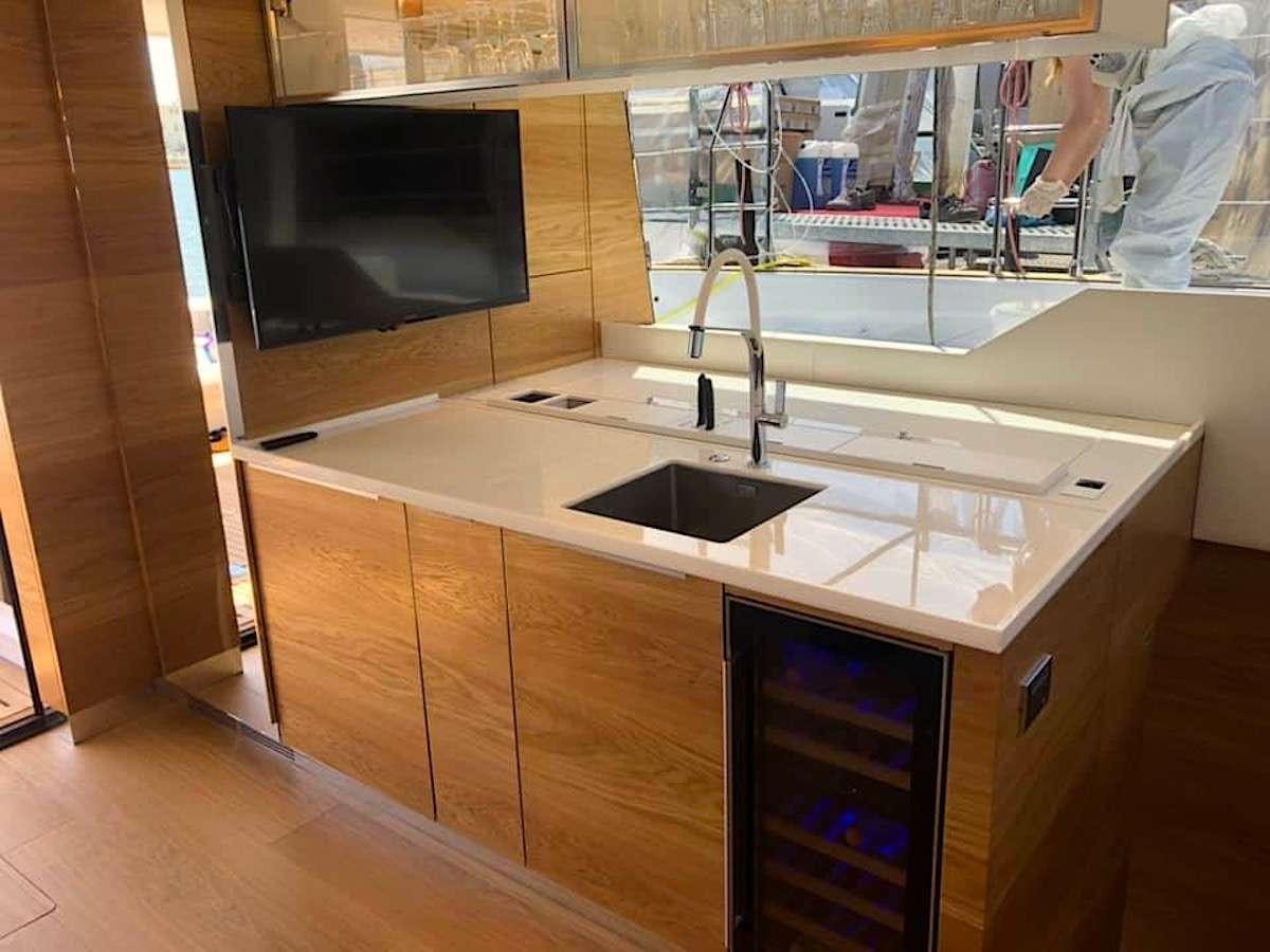 a kitchen with a sink and a microwave aboard TIRIL Yacht for Charter