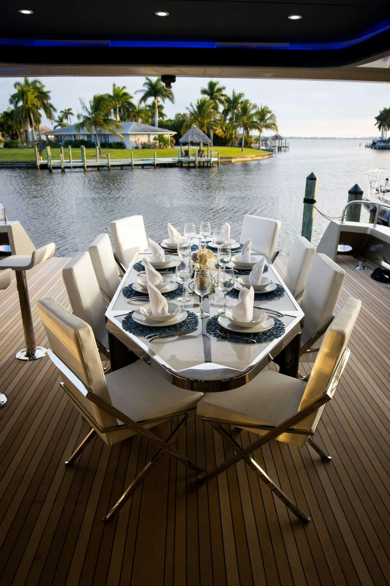 a table set with chairs and a body of water aboard JULIANNE Yacht for Charter