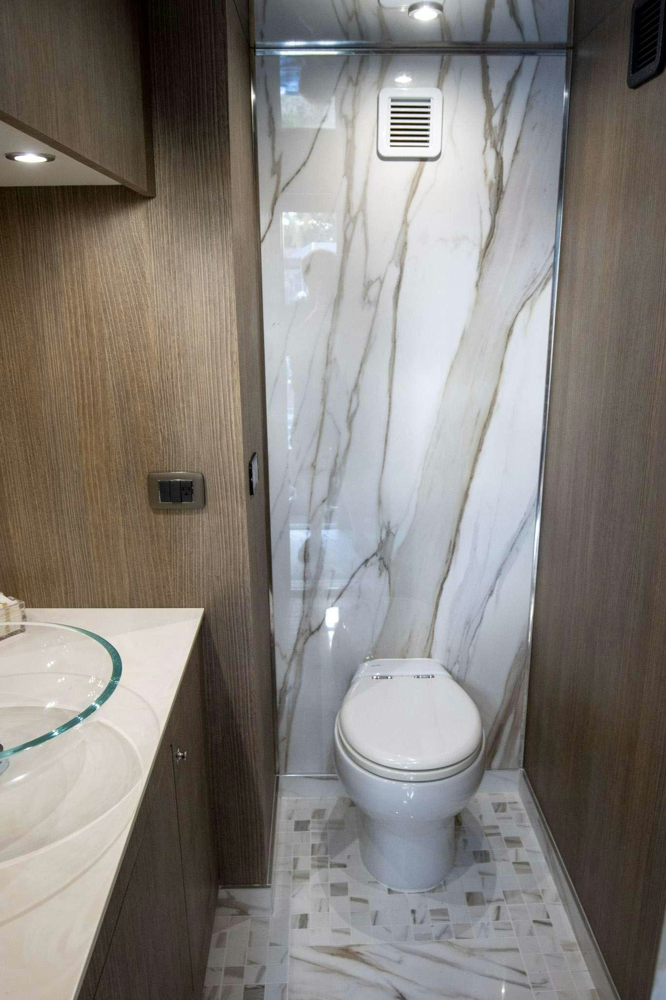 a bathroom with a toilet and a shower curtain aboard JULIANNE Yacht for Charter