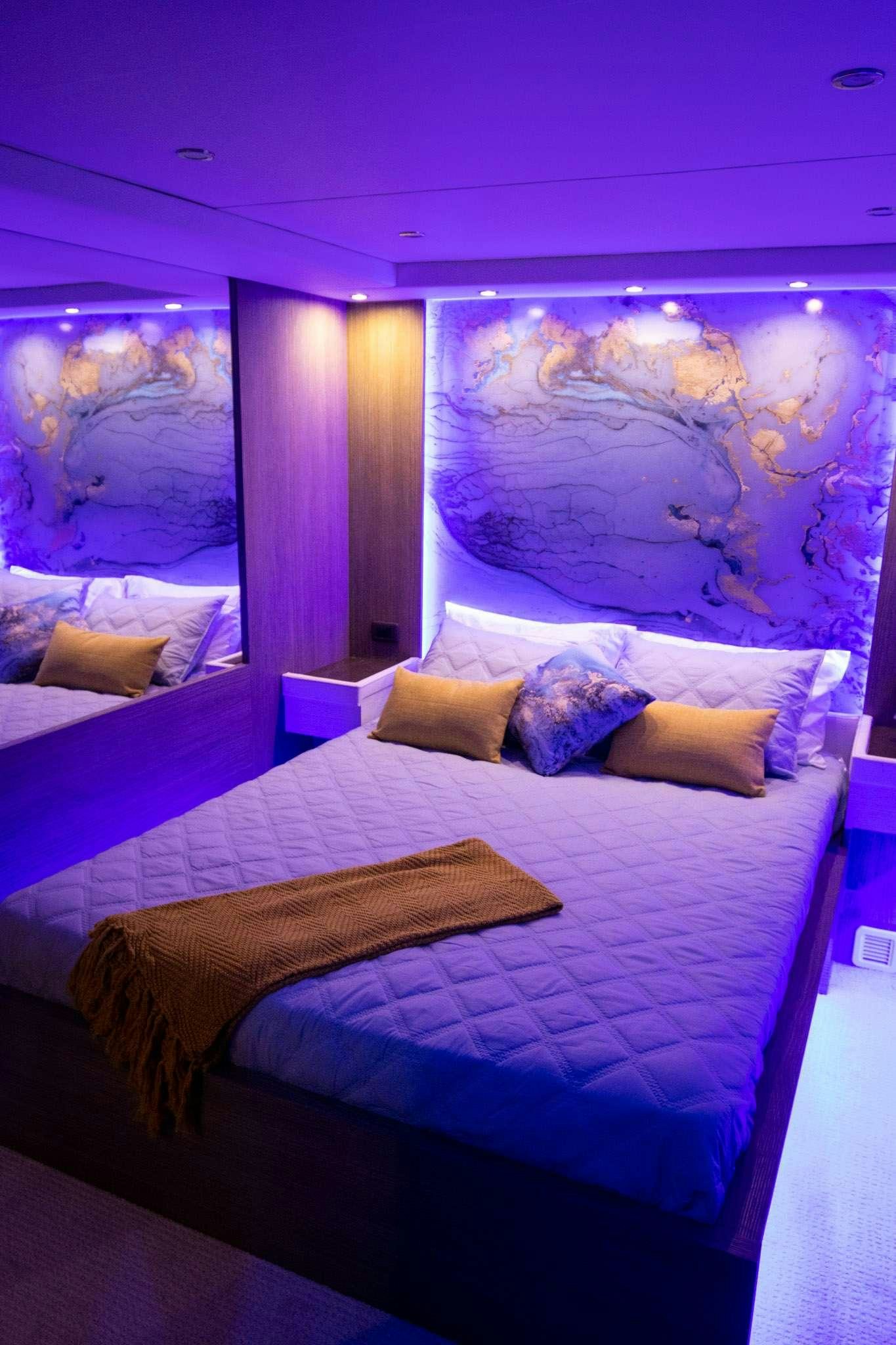 a bed with a painting on the wall aboard JULIANNE Yacht for Charter