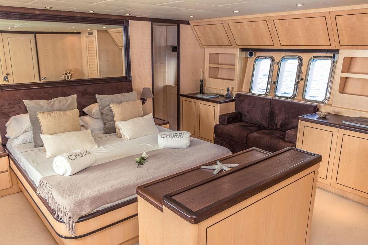 a bedroom with a bed and a leather couch aboard CHURRI Yacht for Charter