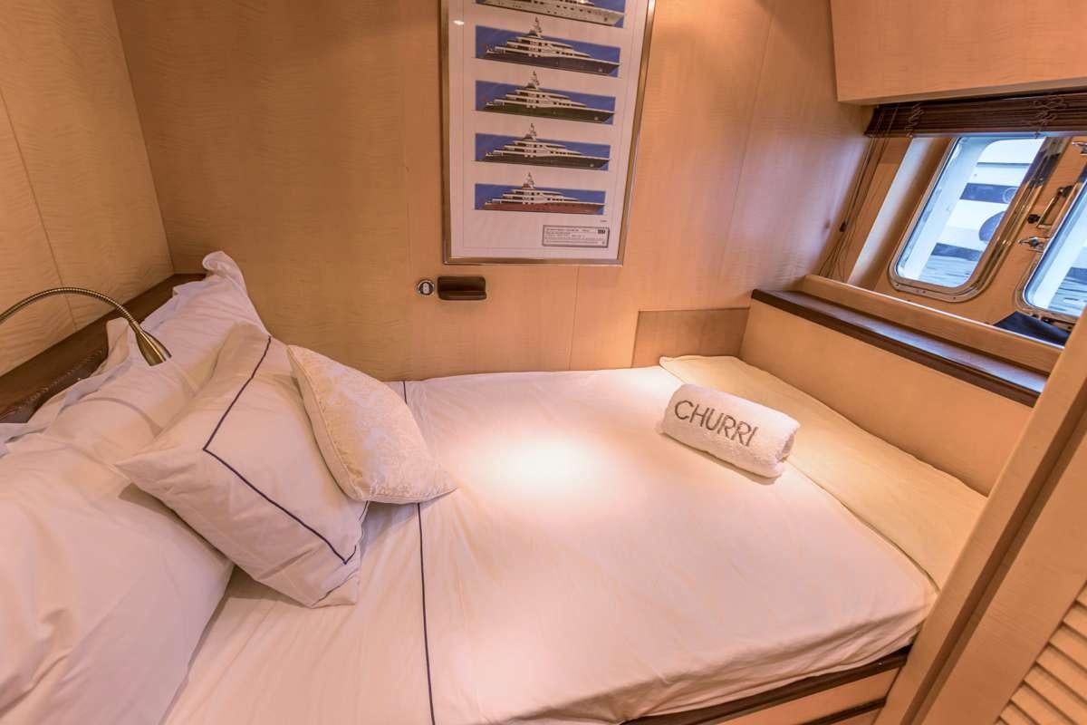 a bed with a white pillow aboard CHURRI Yacht for Charter