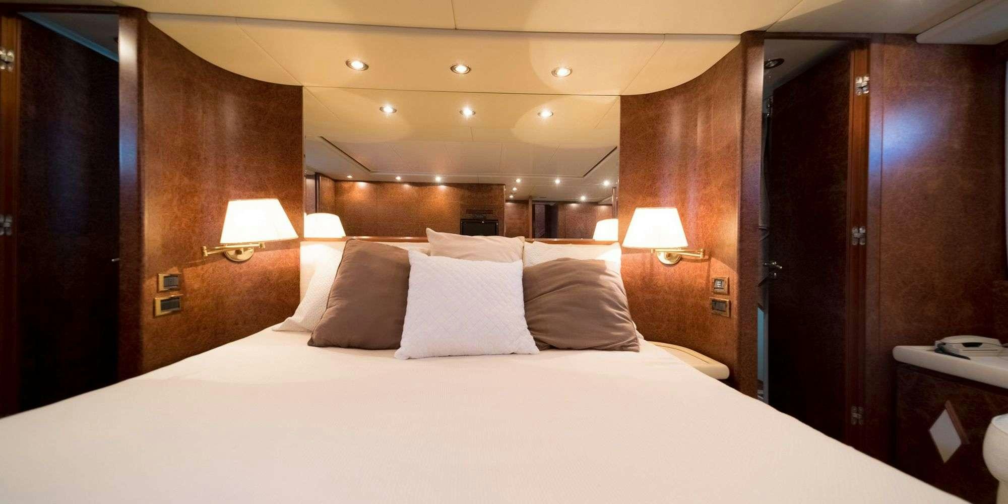 a bed with white sheets aboard OLA Yacht for Charter