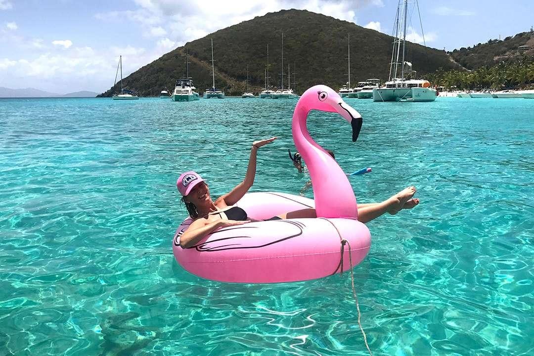 a person and a pink float in a lake with a pink duck aboard QUEST Yacht for Charter