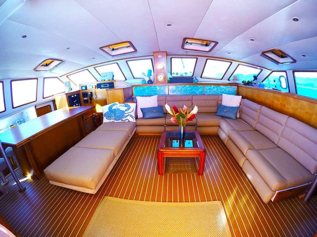 a living room with a couch and a table aboard QUEST Yacht for Charter
