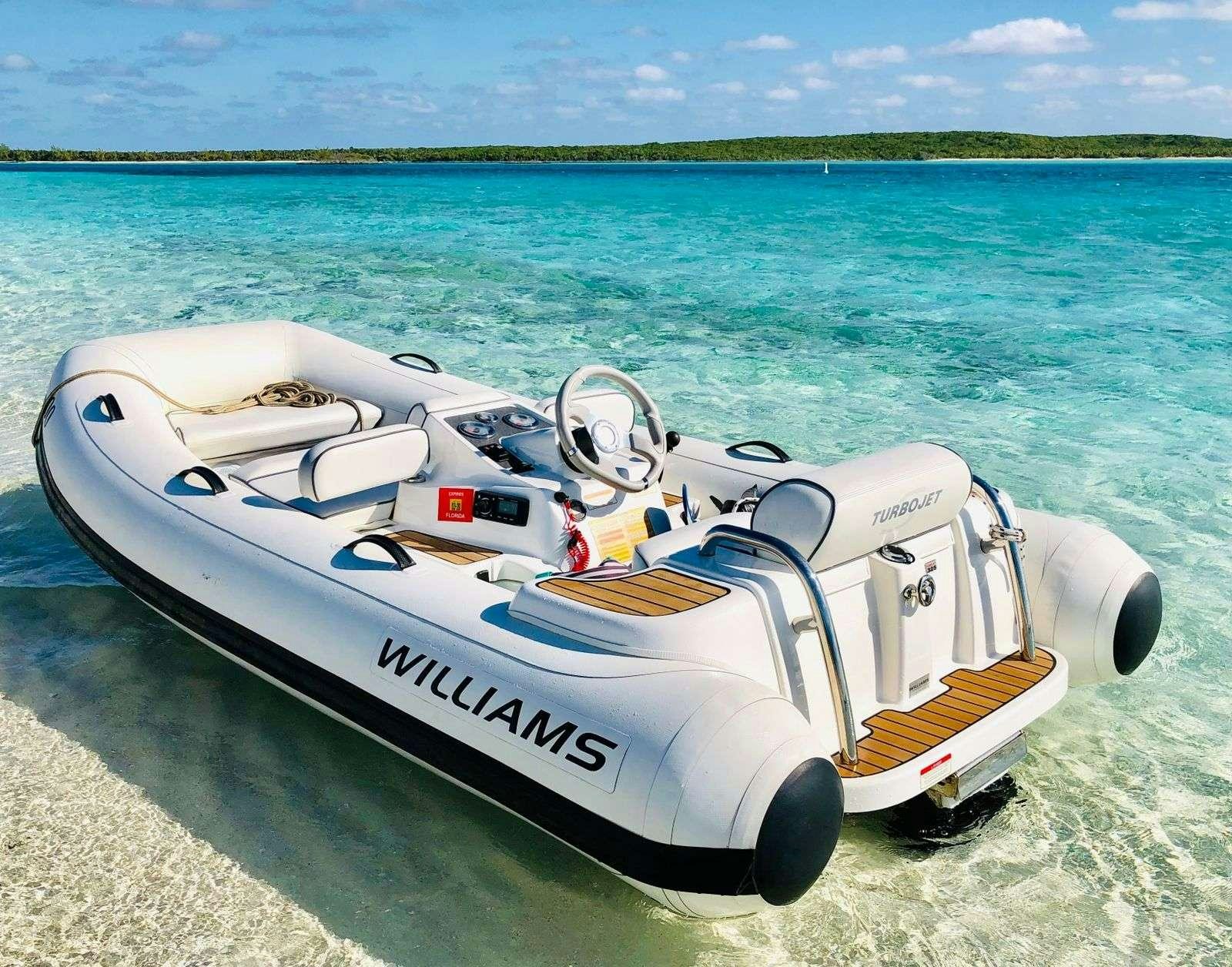 a white and black race car on a beach aboard LEONARDO Yacht for Charter