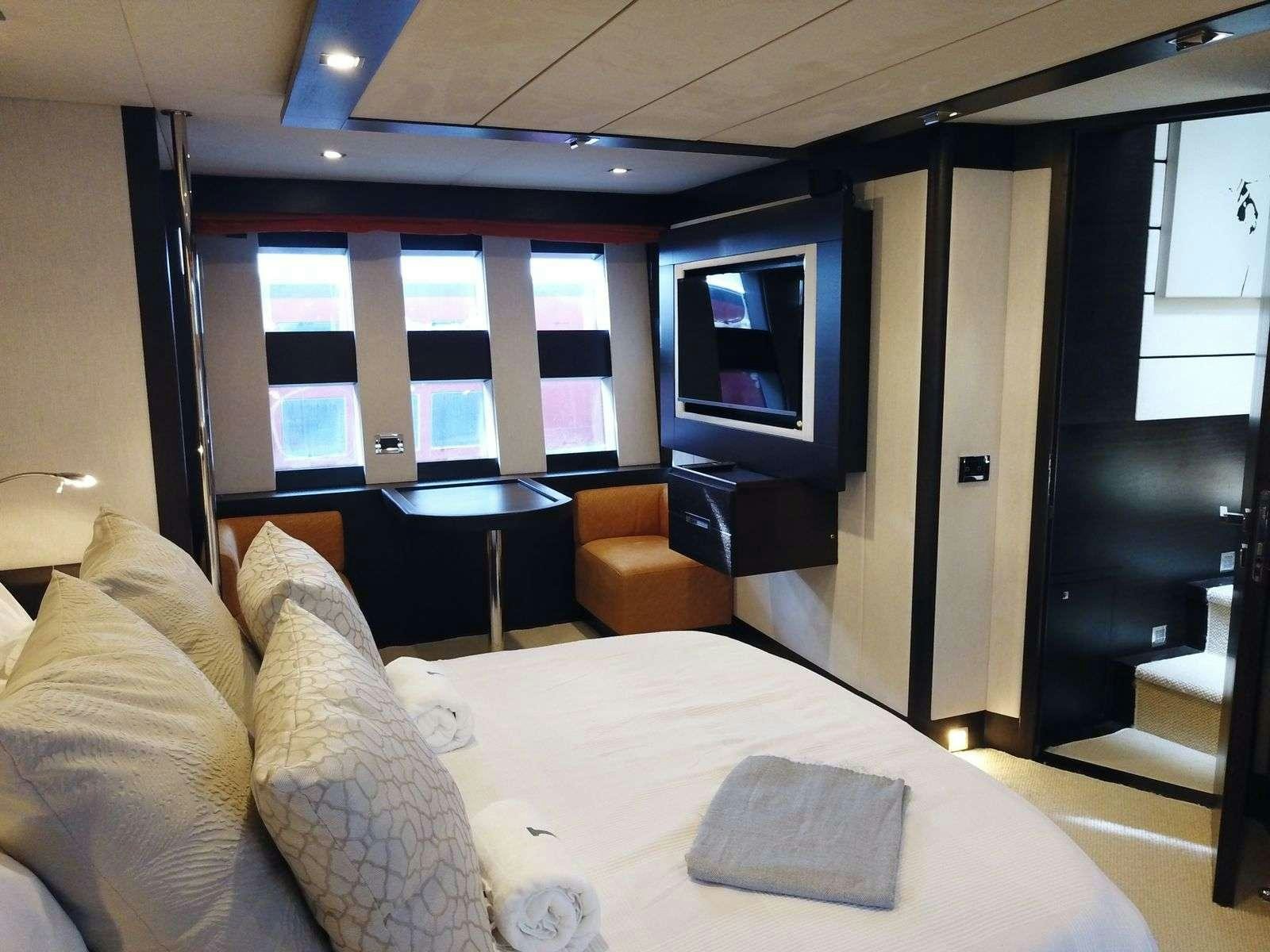 a hotel room with a bed and a tv aboard LEONARDO Yacht for Charter