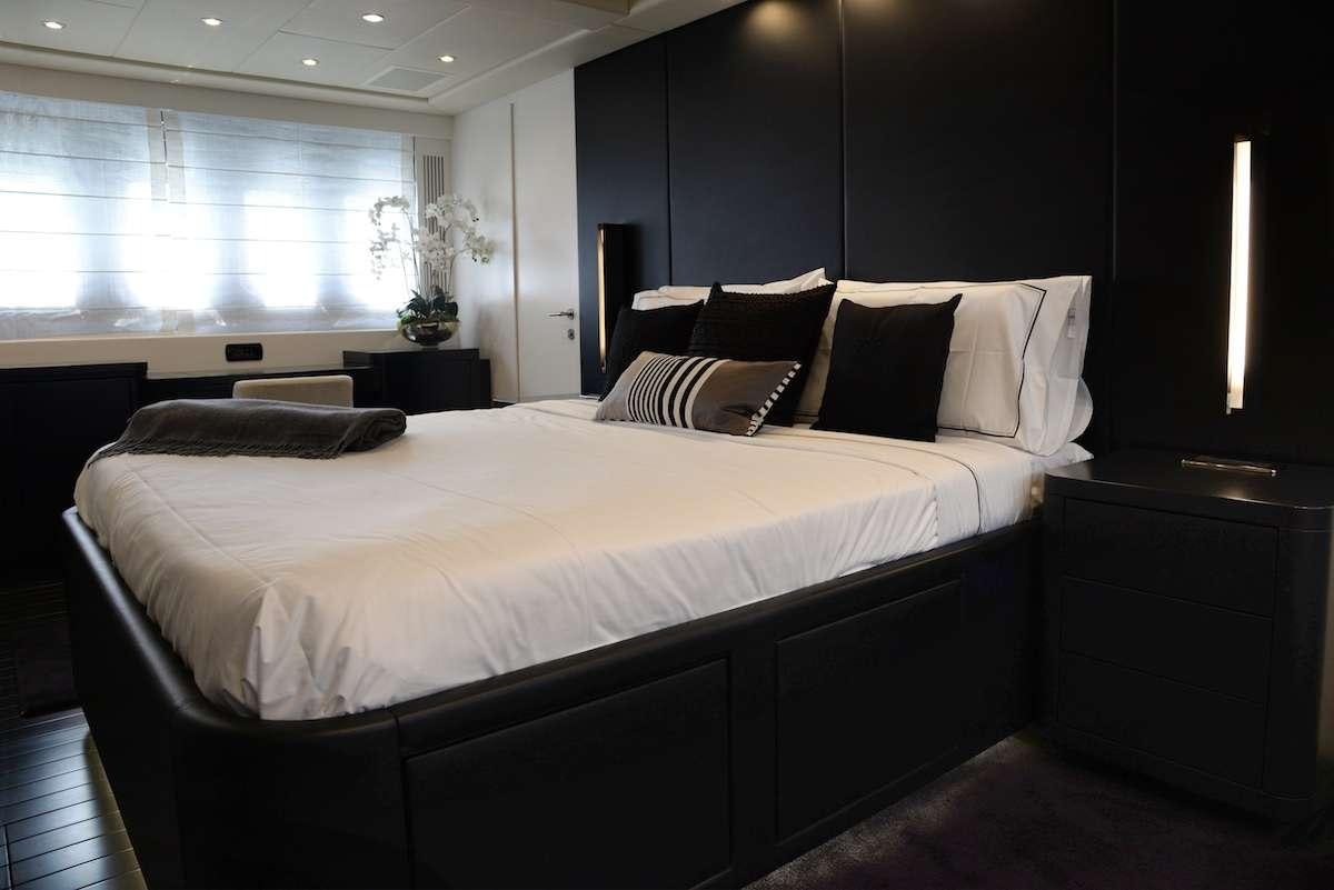 a large bed with white sheets aboard ONLY ONE Yacht for Charter