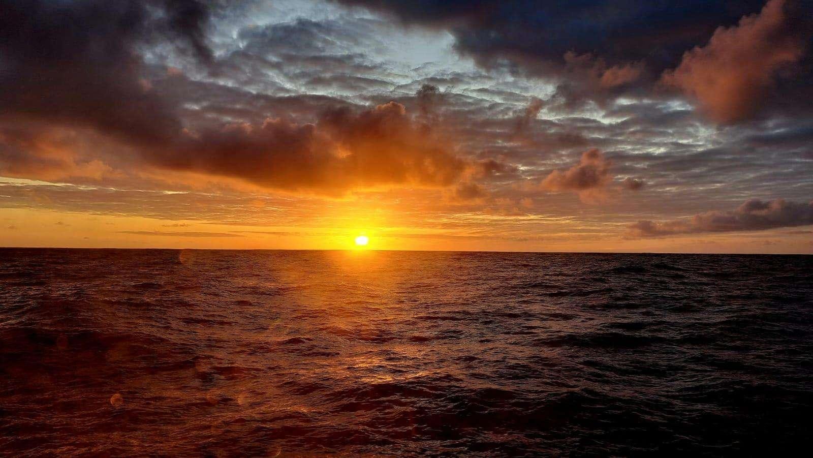 a sunset over a large body of water aboard TANANA Yacht for Charter