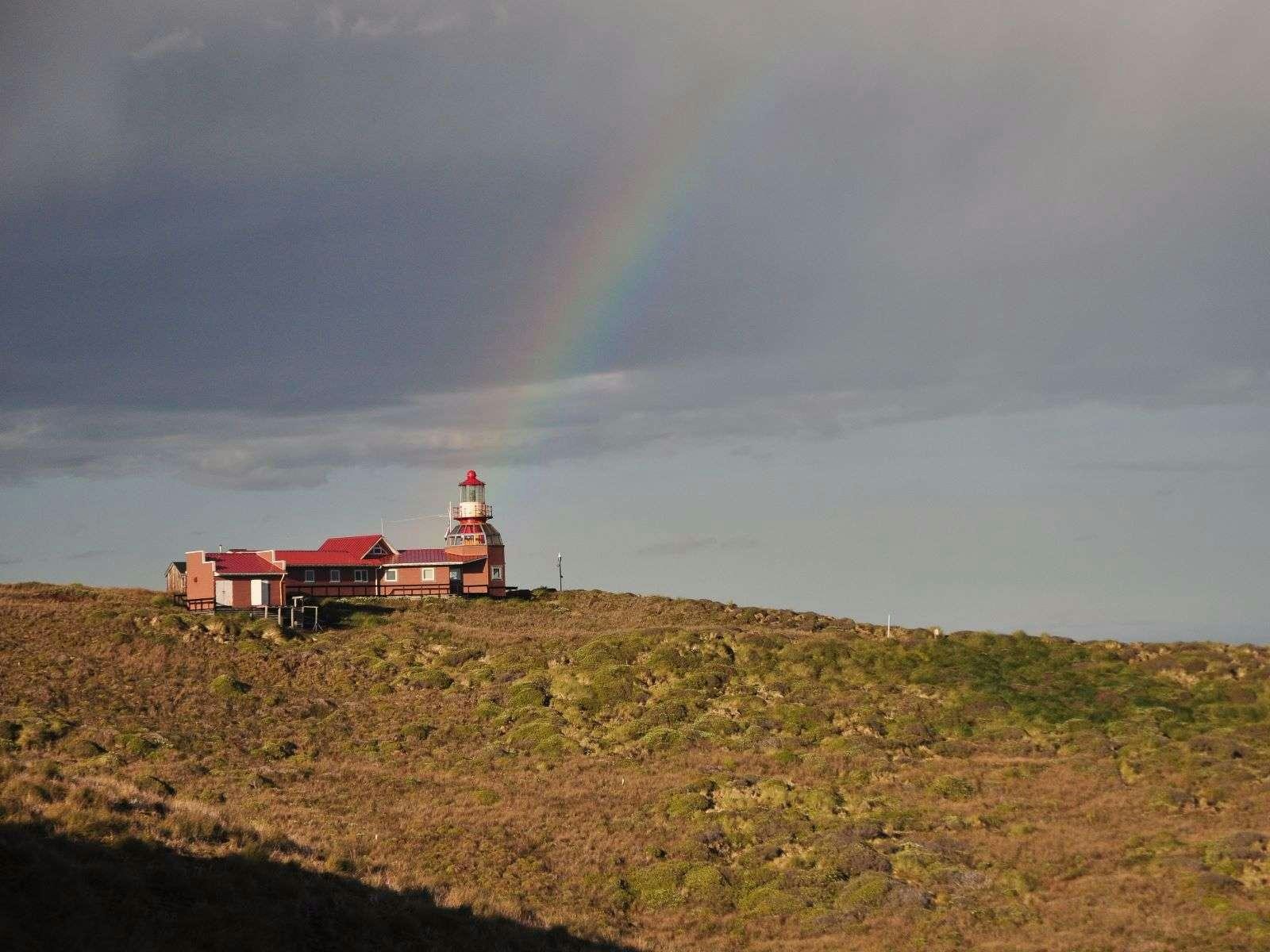 a rainbow over a lighthouse with Fire Island Lighthouse in the background aboard TANANA Yacht for Charter