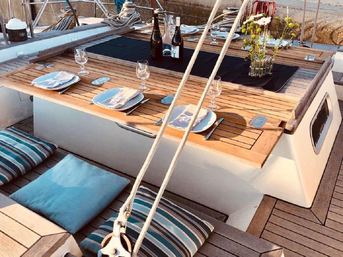 a table with wine bottles and glasses aboard TANANA Yacht for Charter