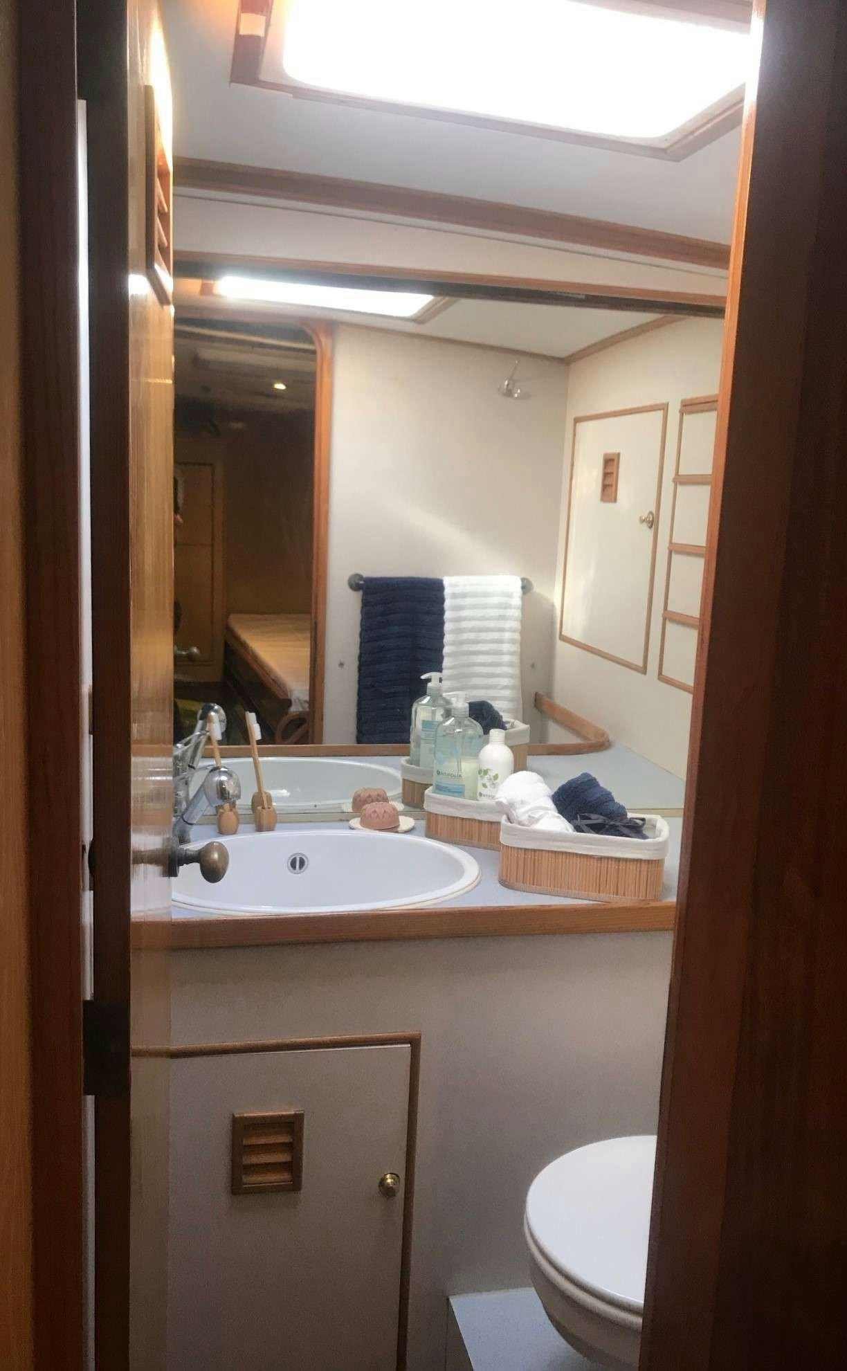 a bathroom with a sink and a mirror aboard TANANA Yacht for Charter