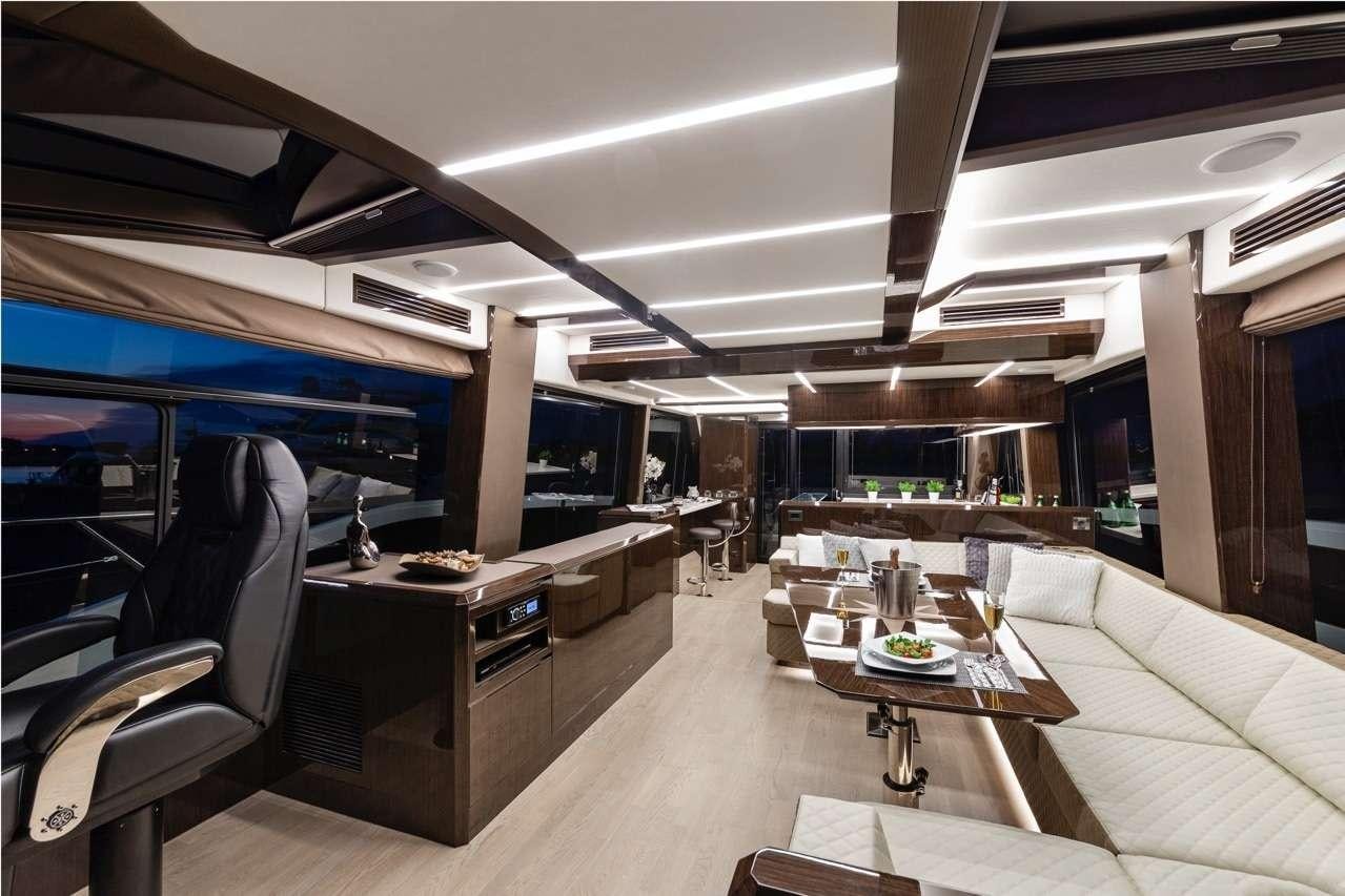 a room with a couch and a table and a tv aboard TRIPLE T Yacht for Charter
