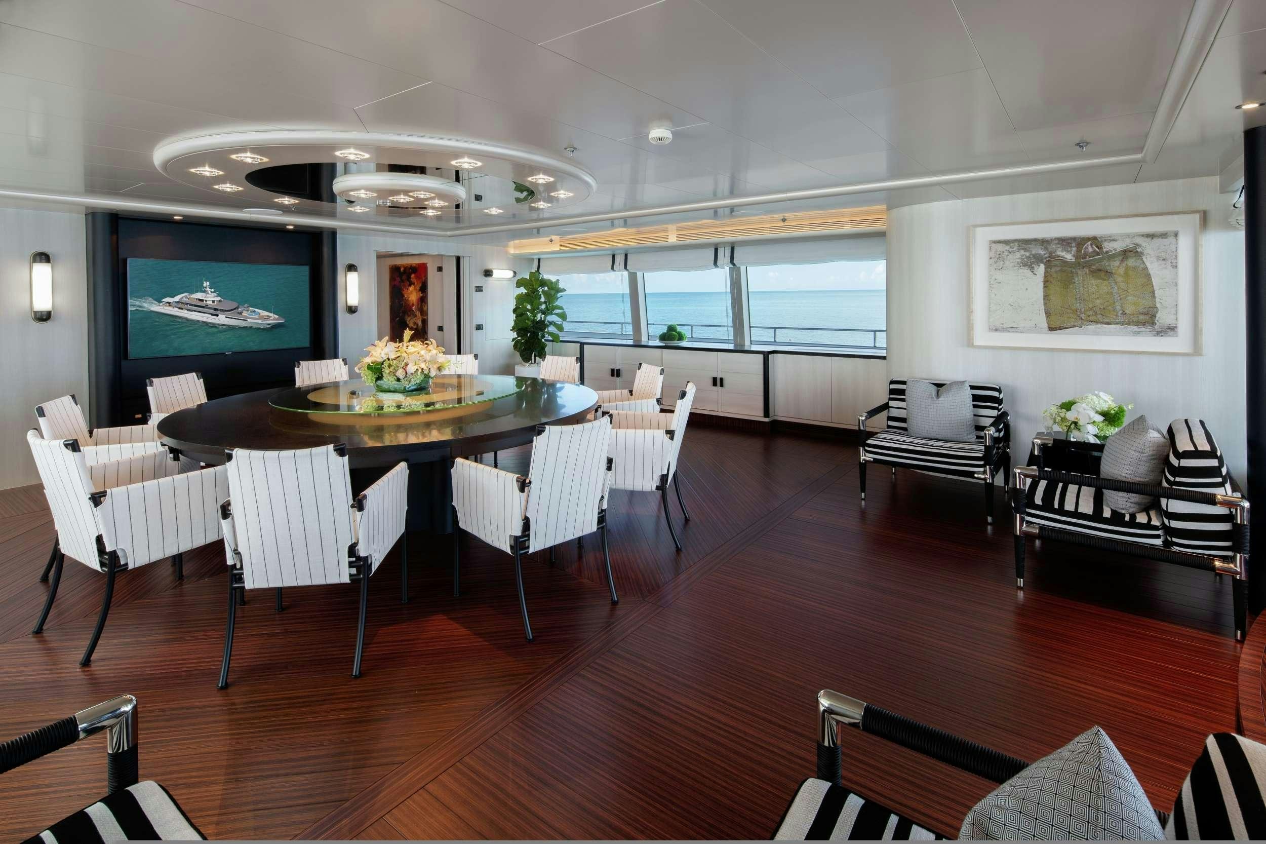 a room with tables and chairs aboard ETERNITY Yacht for Charter