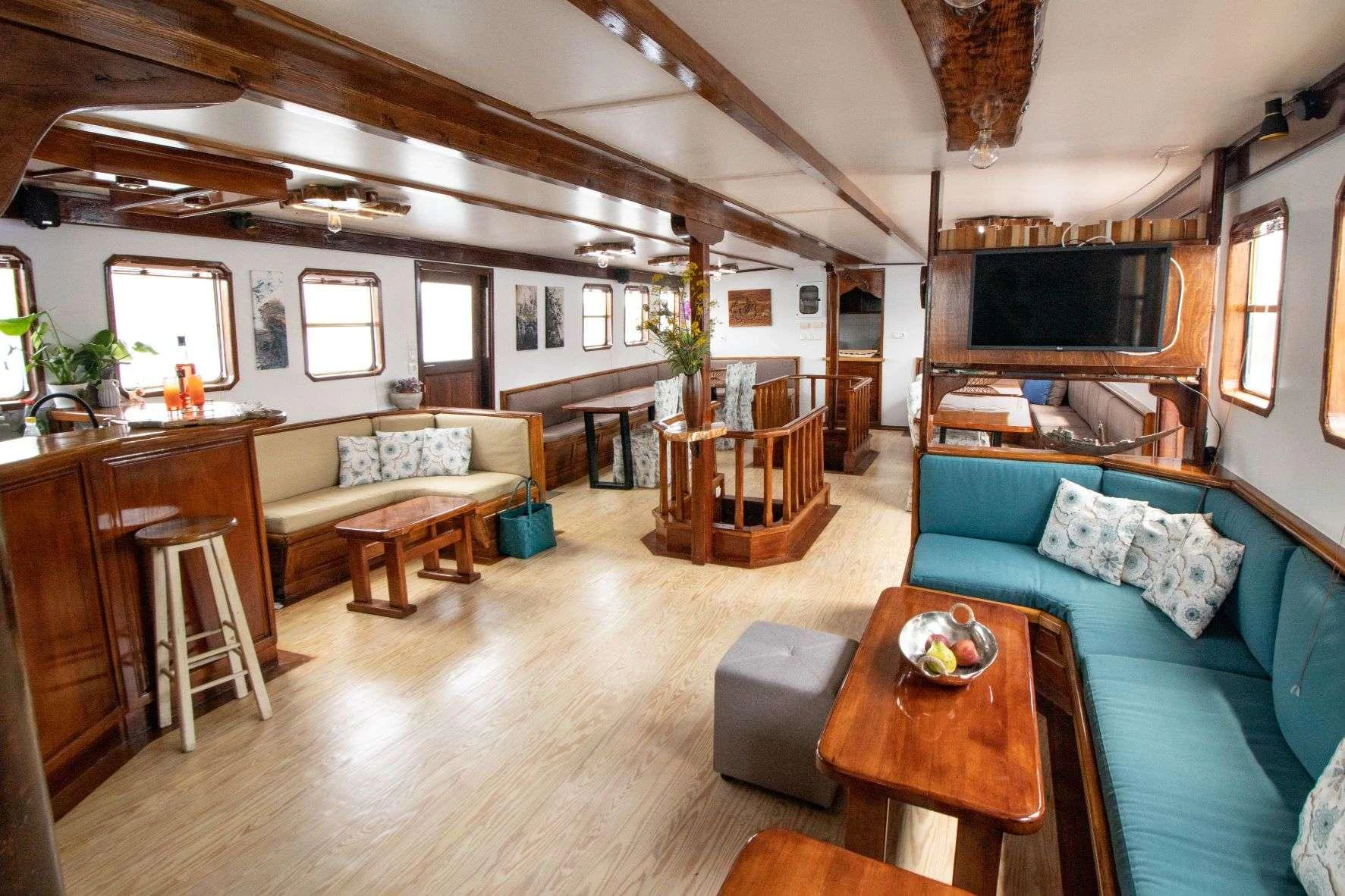 a living room with a blue couch aboard AEGEOTISSA II Yacht for Charter