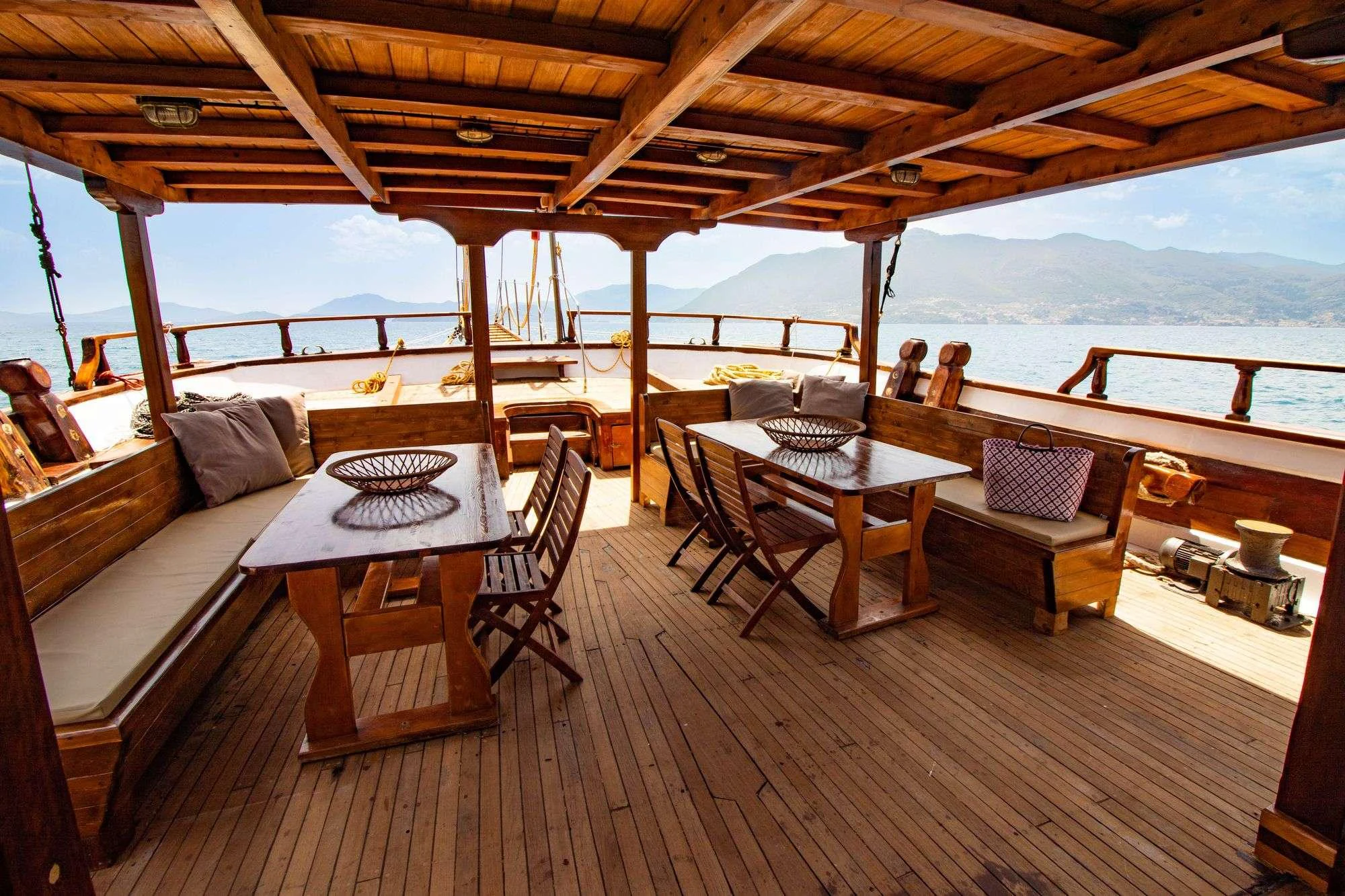 a deck with a table and chairs aboard AEGEOTISSA II Yacht for Charter