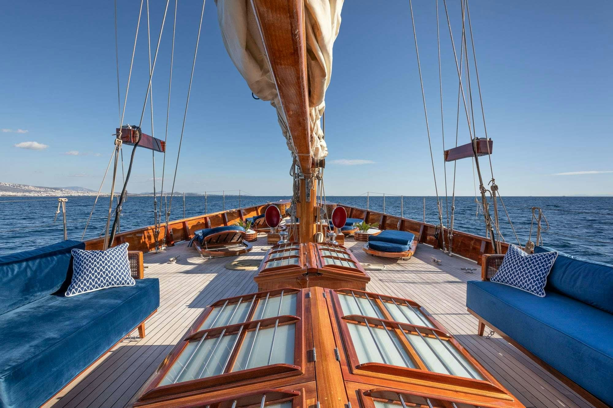 a deck with a boat and chairs on it aboard WEATHER BIRD Yacht for Charter