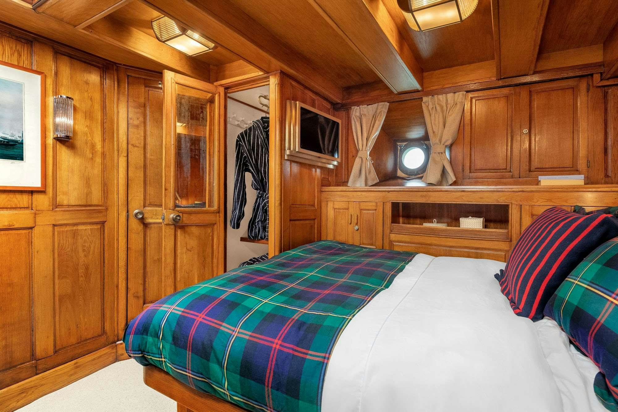 a bedroom with a bed and a closet aboard WEATHER BIRD Yacht for Charter